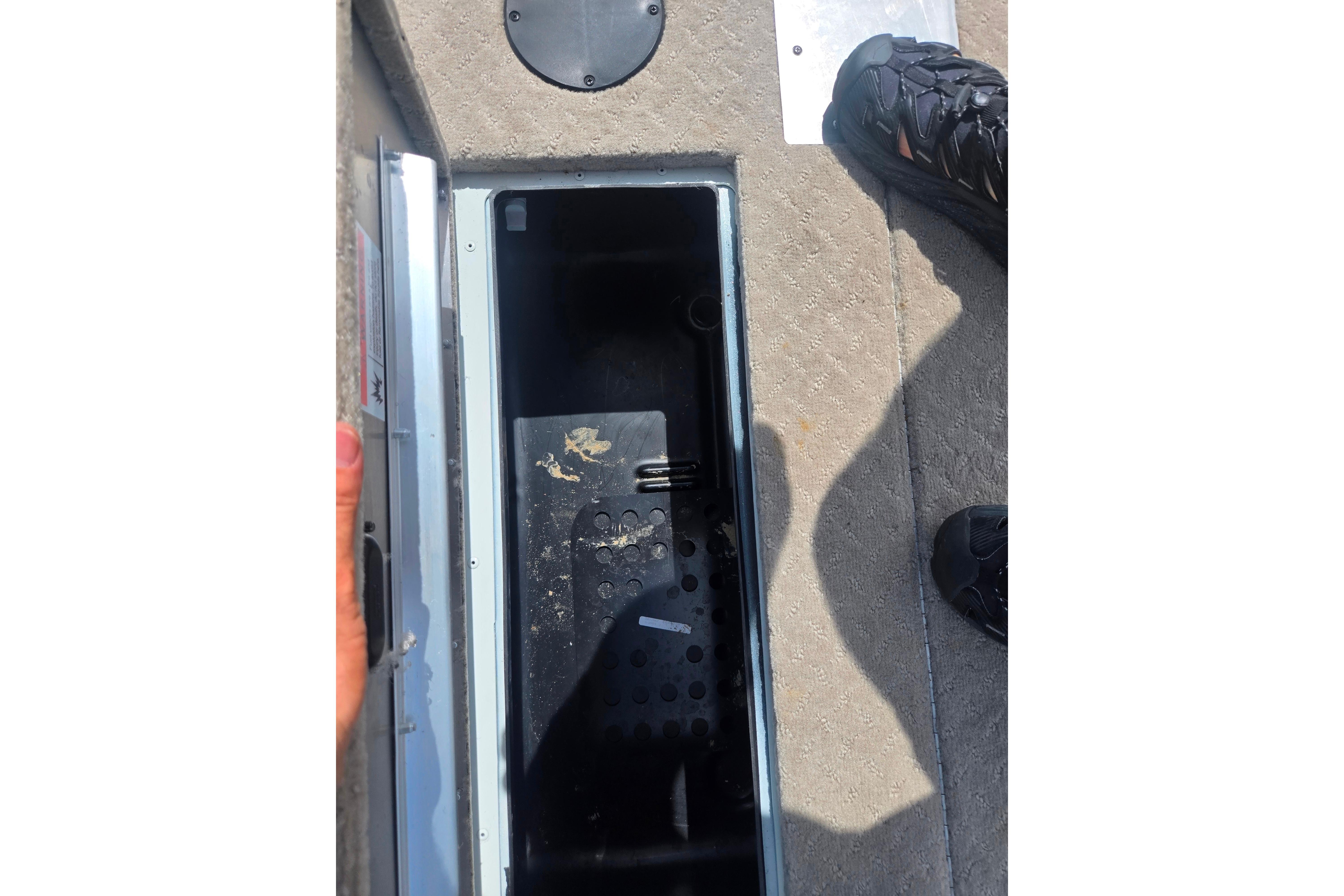 2015 Lowe Sport Deck 224 storage compartment with open lid and visible interior.