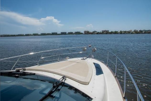 2011 Marquis Sport Coupe cruising on a calm, scenic waterway under a clear blue sky.