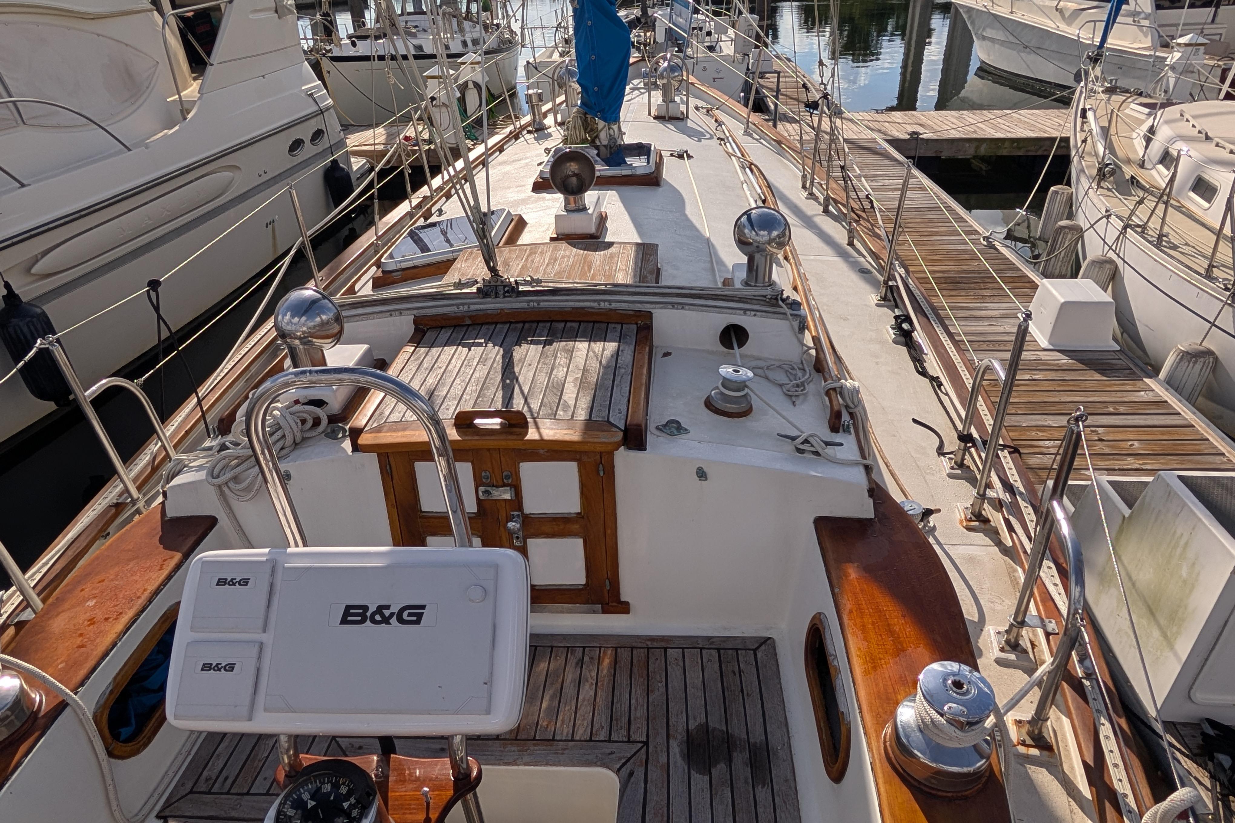 1983 Robert Perry 41 sailboat docked, featuring wooden deck and B&G navigation equipment.