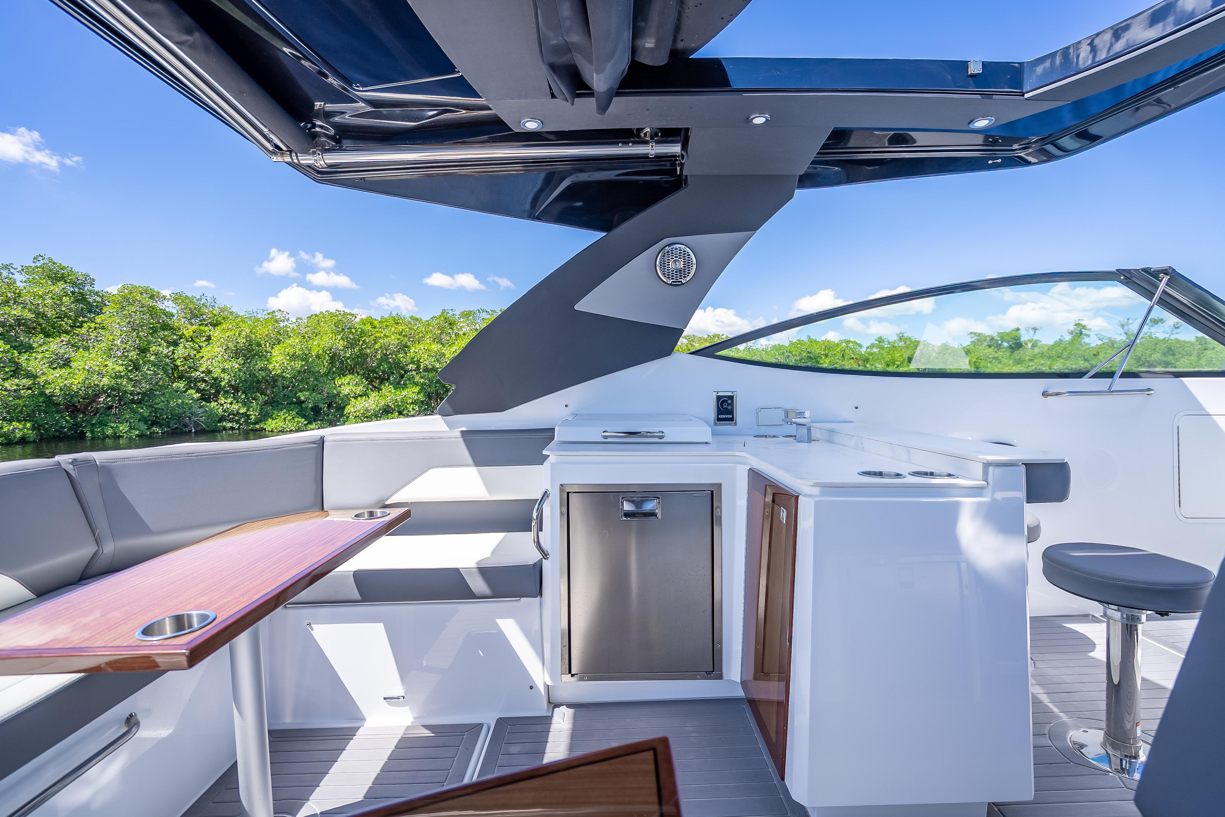 2022 Cruisers Yachts 38 GLS OB interior with seating, kitchenette, and scenic view.