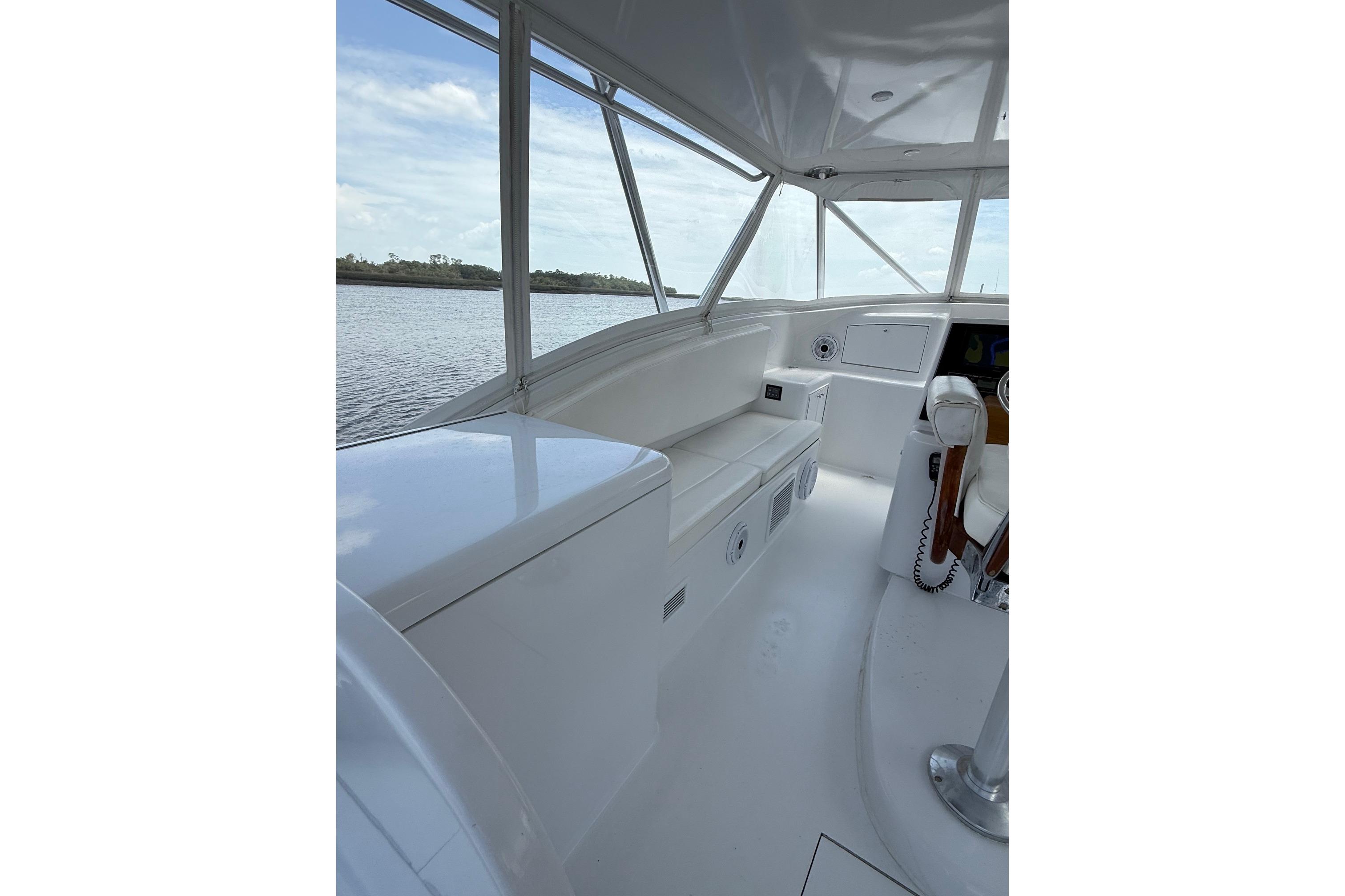 2006 Custom Carolina Heritage Express boat interior with white seating and helm, overlooking water.