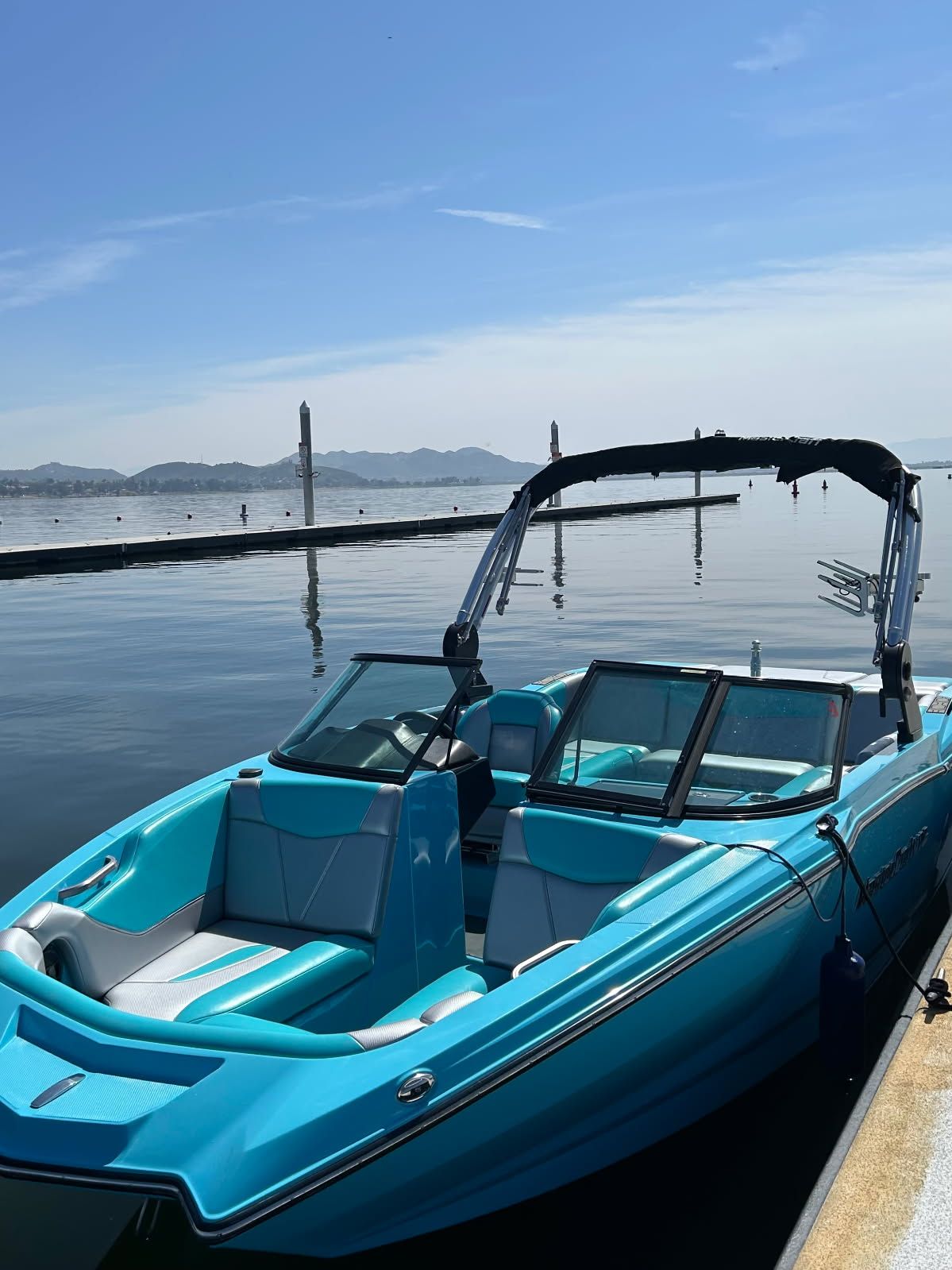 2021 MasterCraft NXT22 boat on calm water under sunny skies.