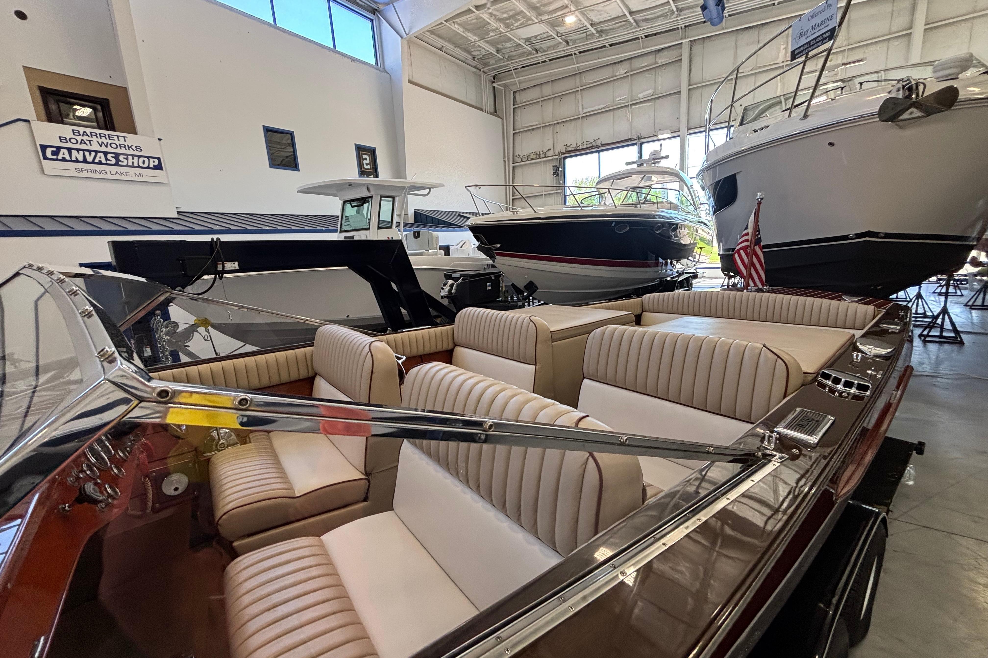 1997 Grand Craft 24 Luxury Sport boat in showroom with other vessels.