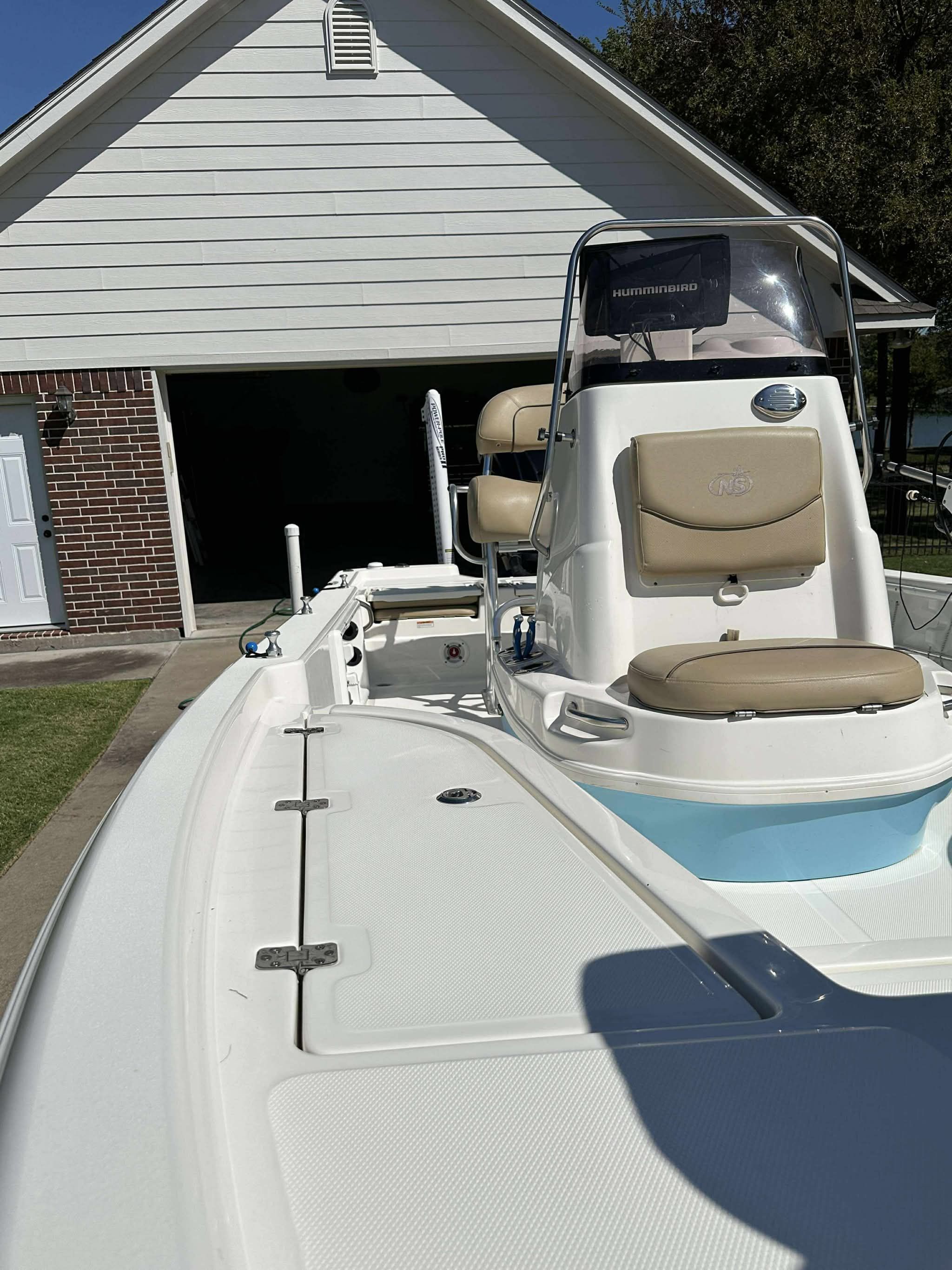 2019 NauticStar 215 XTS Shallow Bay boat in front of garage.