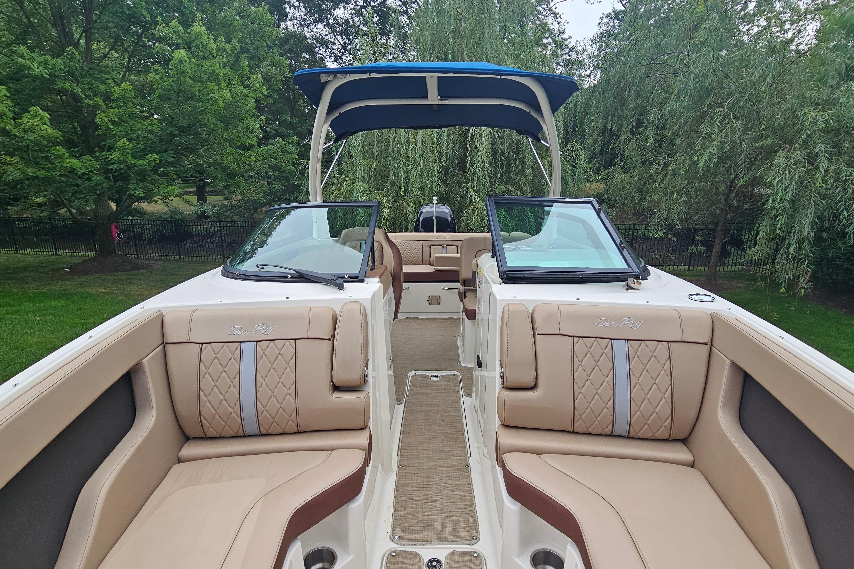2017 Sea Ray SDX 240 Outboard boat interior with tan seating and blue canopy.