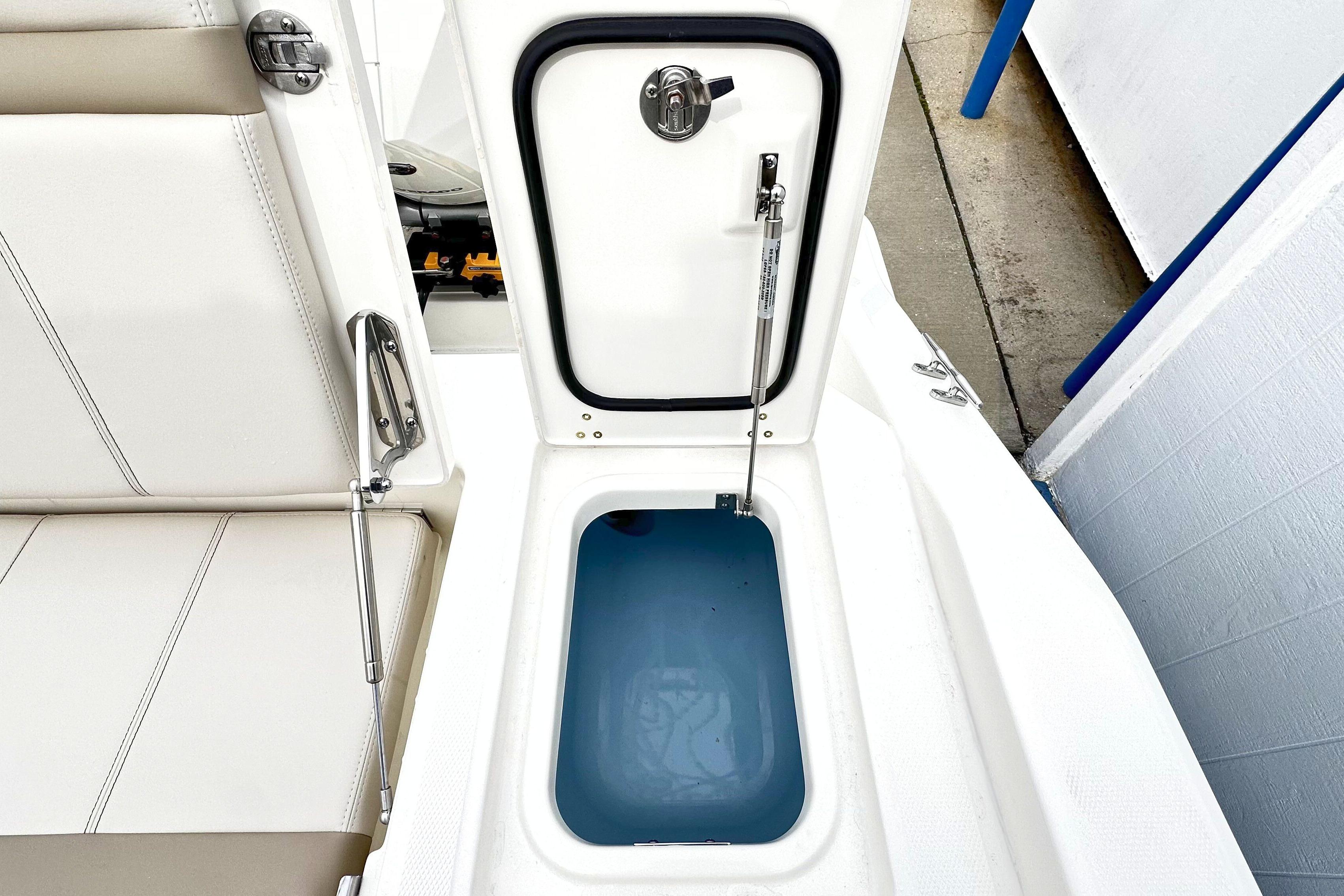 Open storage compartment on 2026 Boston Whaler 280 Dauntless boat, showcasing interior details.