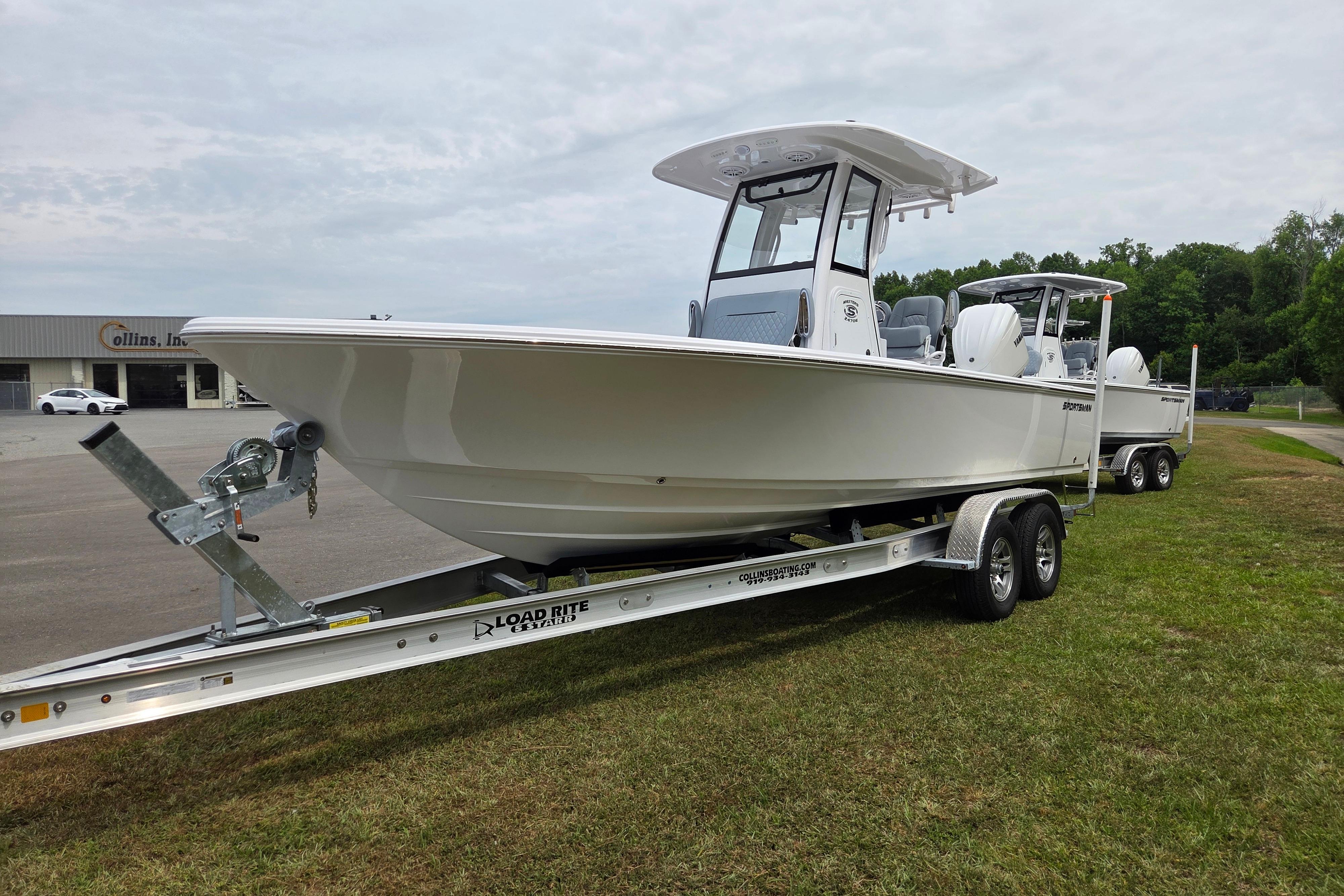 2026 Sportsman Masters 247OE Bay Boat on trailer, parked on grass.