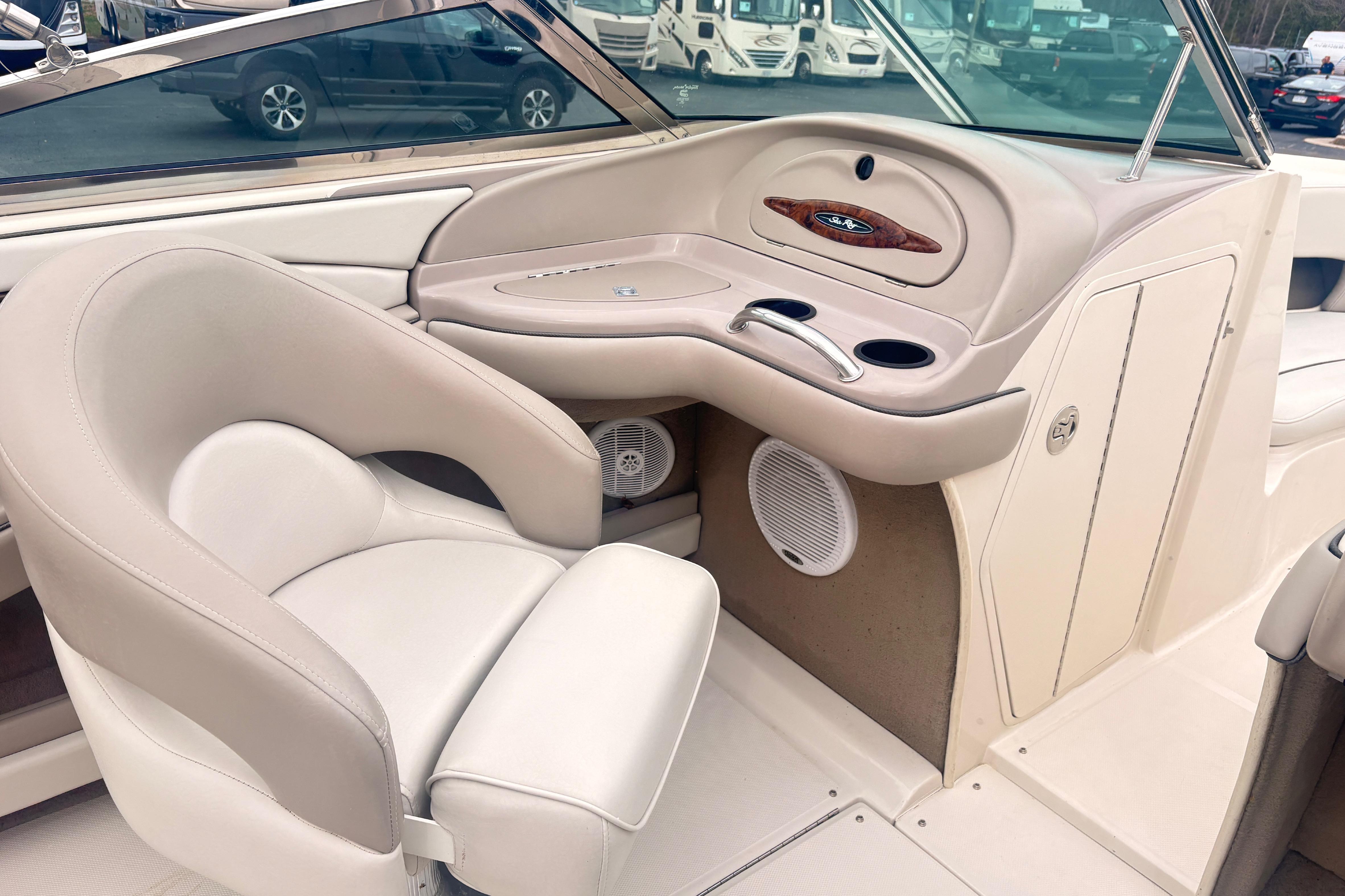 Interior of 2003 Sea Ray 240 Bow Rider boat with beige seating and dashboard.
