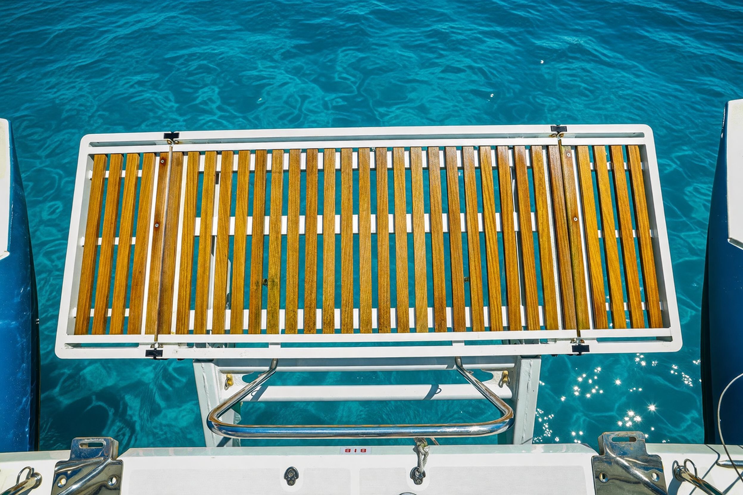 Teak platform on Lagoon 450 F, 2017, above turquoise water.