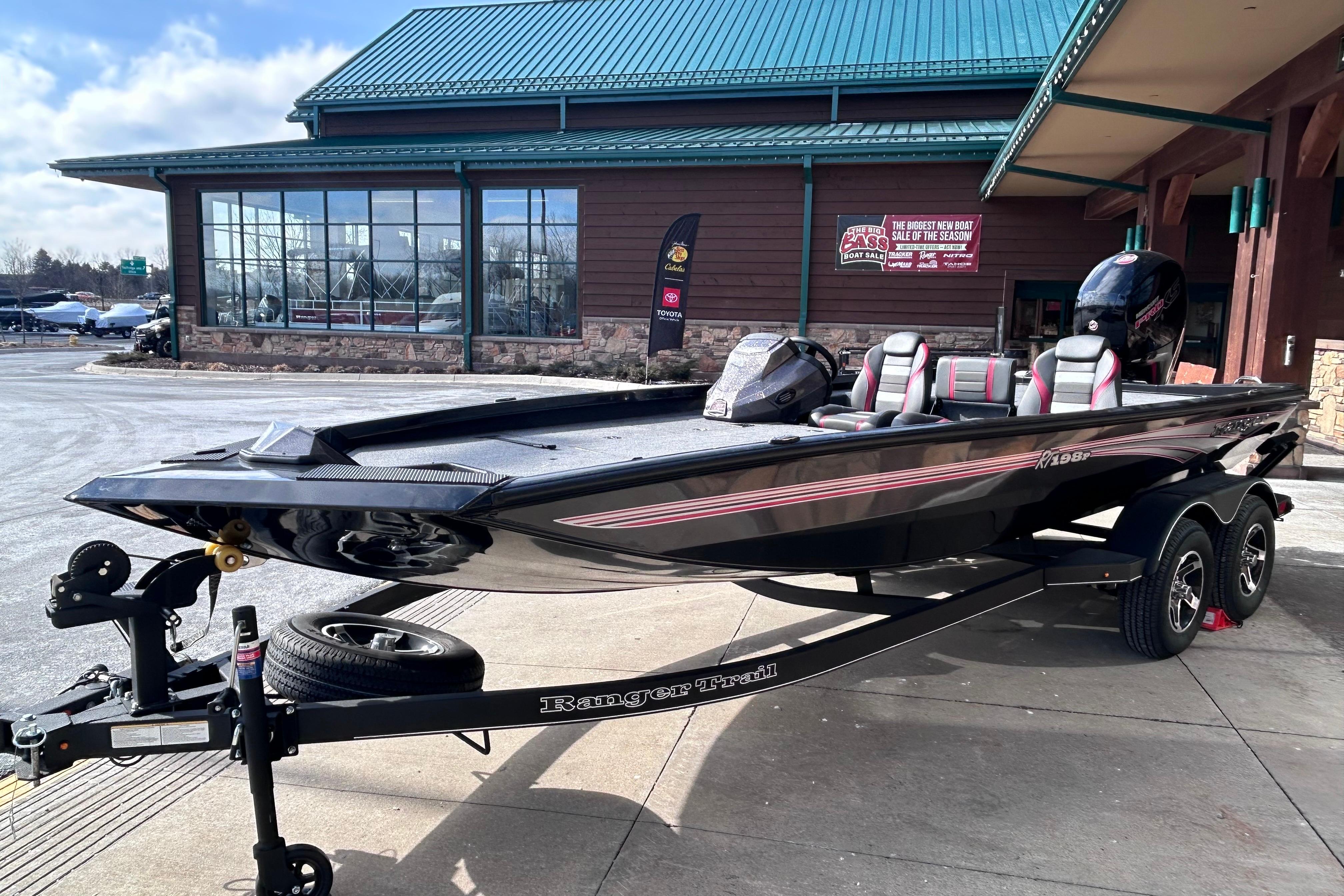 2025 Ranger RT198P boat on trailer outside a showroom, showcasing sleek design.