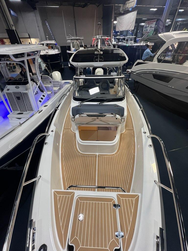 2025 Nimbus Tender 8 boat with sleek design and wooden deck, showcased indoors.
