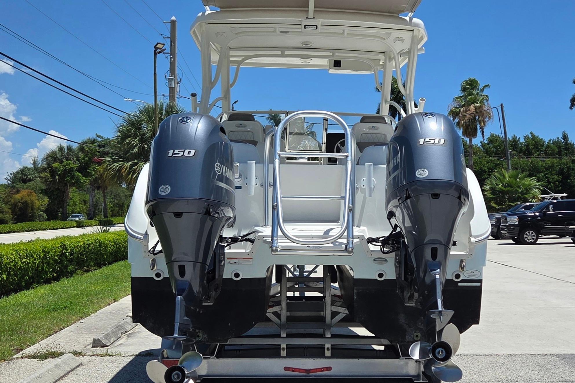 2022 World Cat 255 DC boat with dual Yamaha 150 engines, parked outdoors.