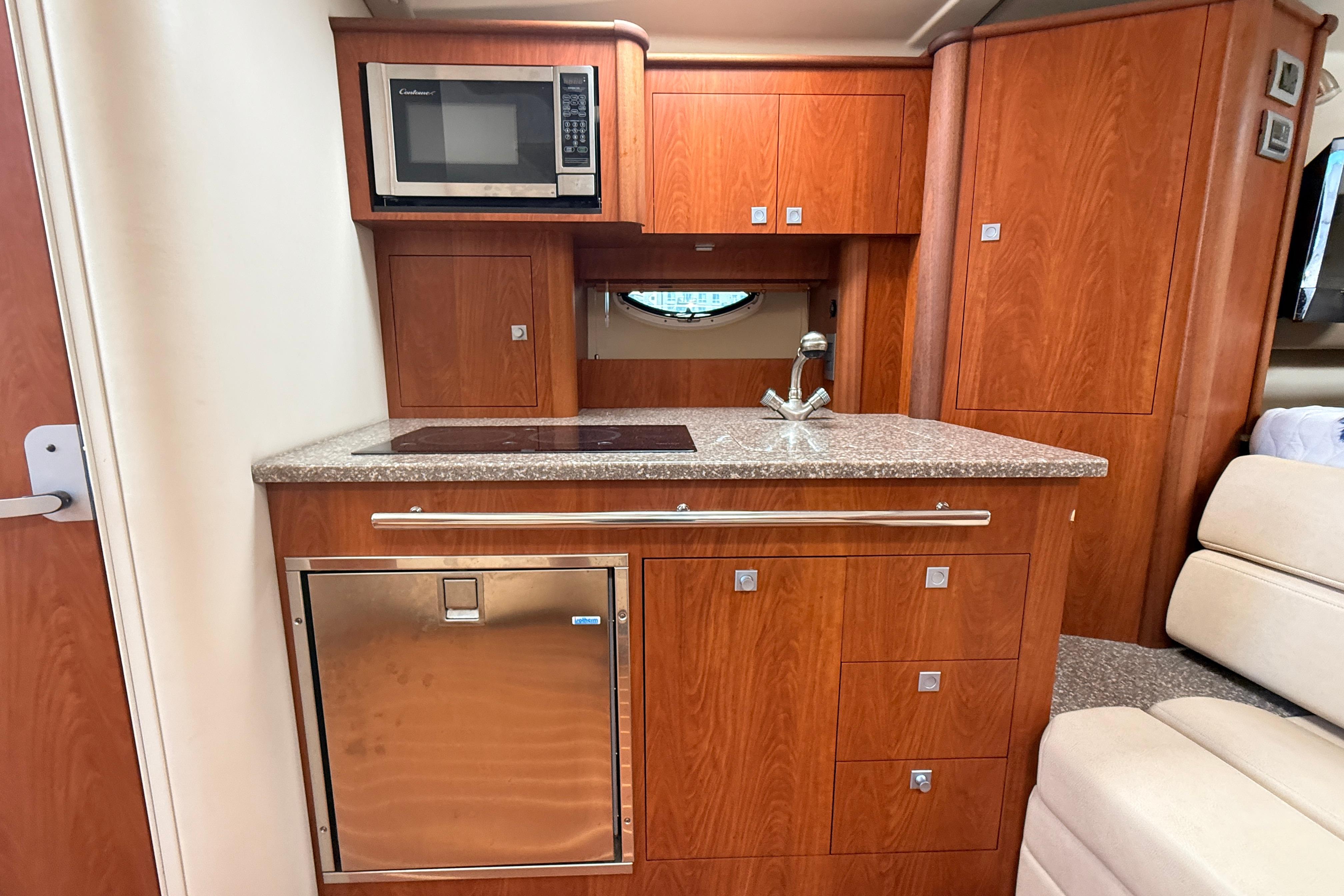 Luxurious 2011 Monterey 320 Sport Yacht interior kitchen with wood cabinetry and modern appliances.