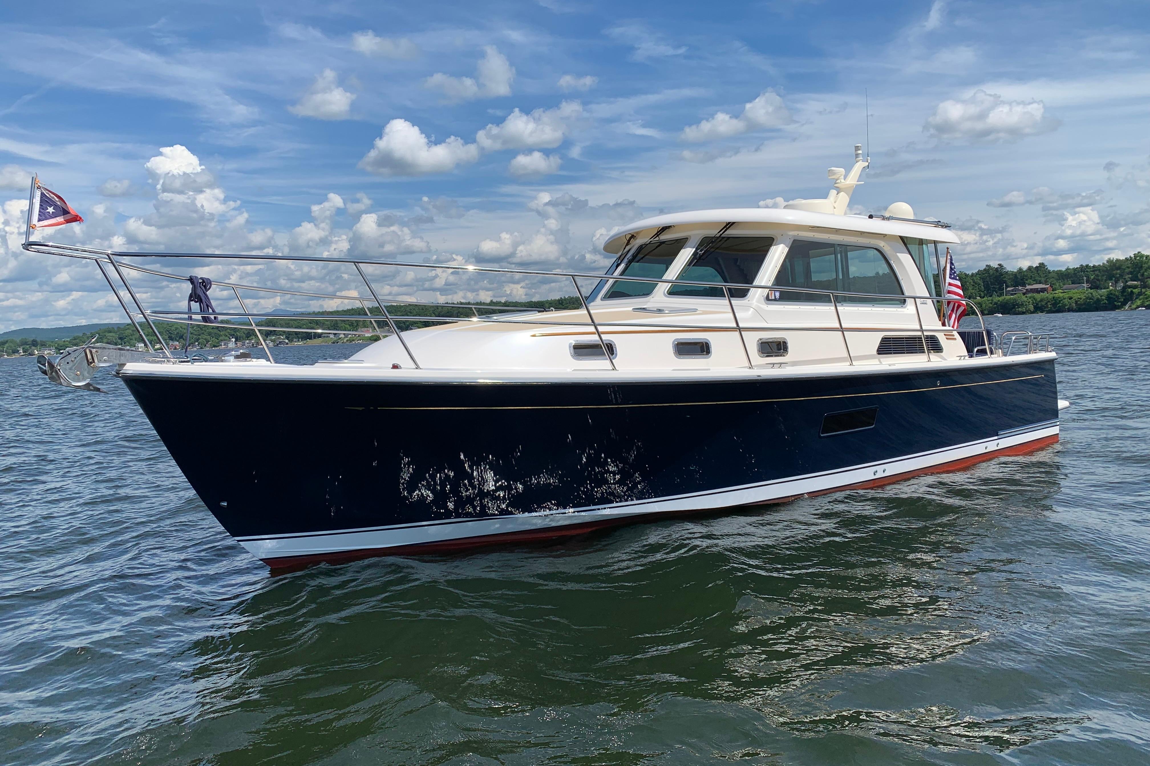 2015 Sabre 38 Salon Express yacht cruising on a sunny day with scenic water backdrop.