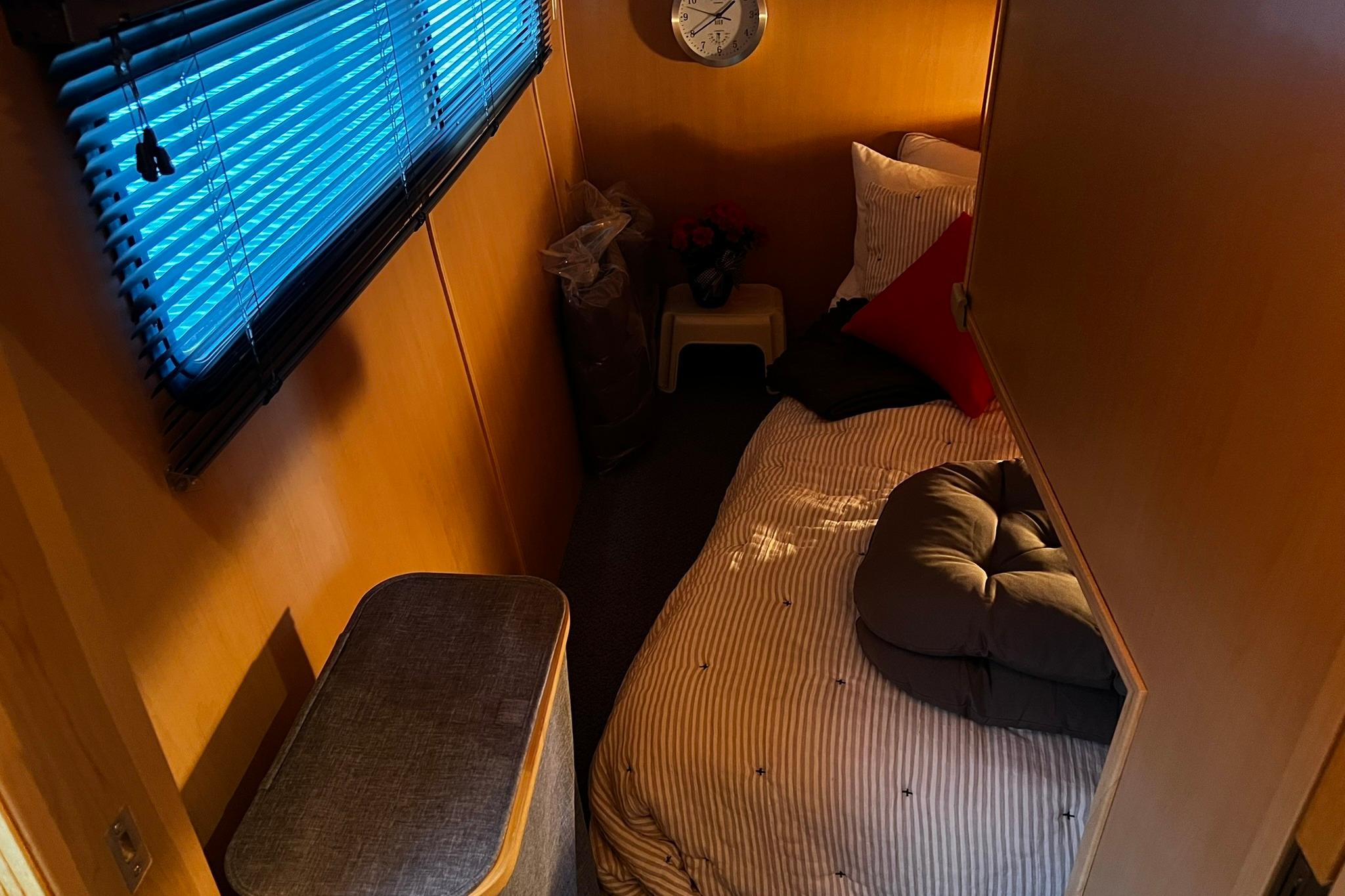 Cozy cabin interior of 2010 Skipperliner 480 Flybridge with bed and window blinds.
