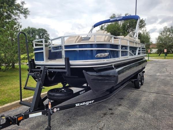 2024 Ranger Reata 223F pontoon boat on trailer, parked outdoors.