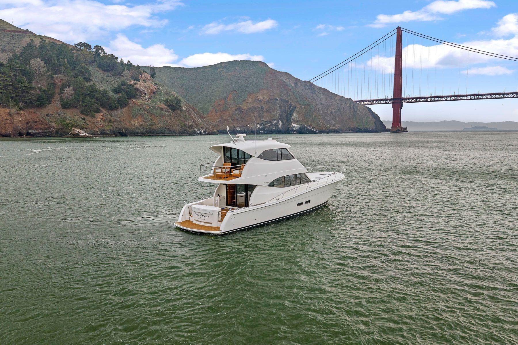 2014 Maritimo M50 yacht cruising near iconic red suspension bridge.