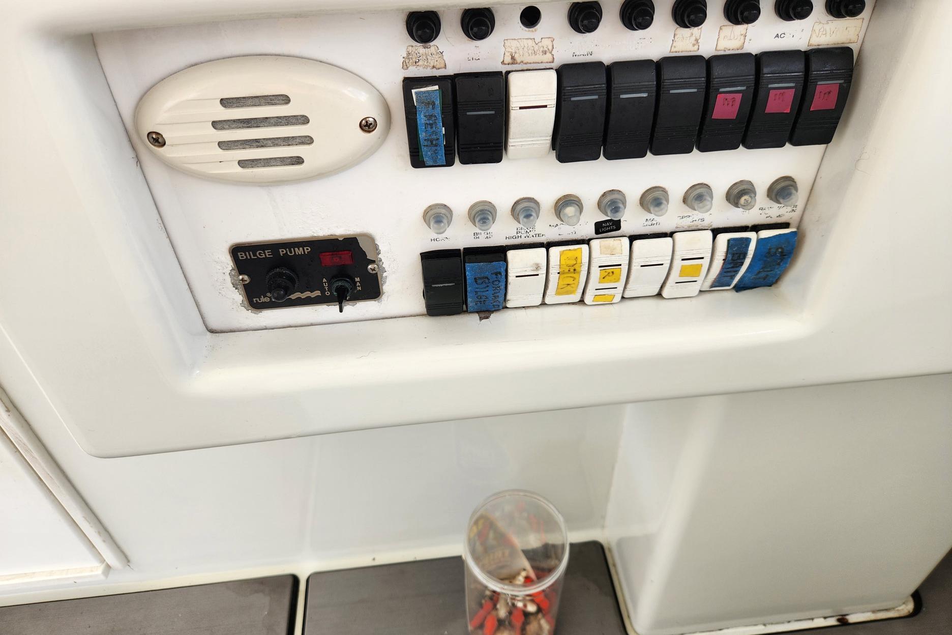 Control panel of a 1987 Young Brothers Custom Sport Fish boat with switches and bilge pump.