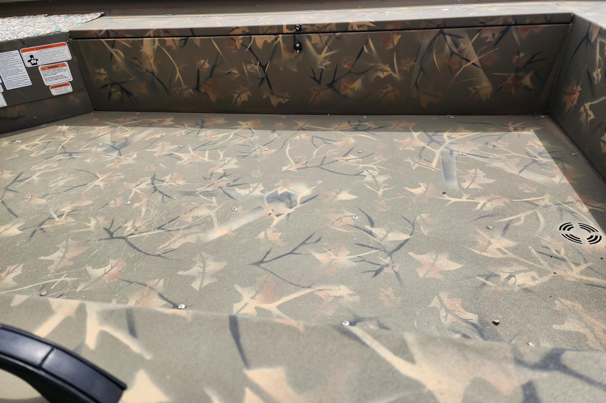 2022 GRIZZLEY 1654SPT boat interior with camouflage pattern and storage compartment.