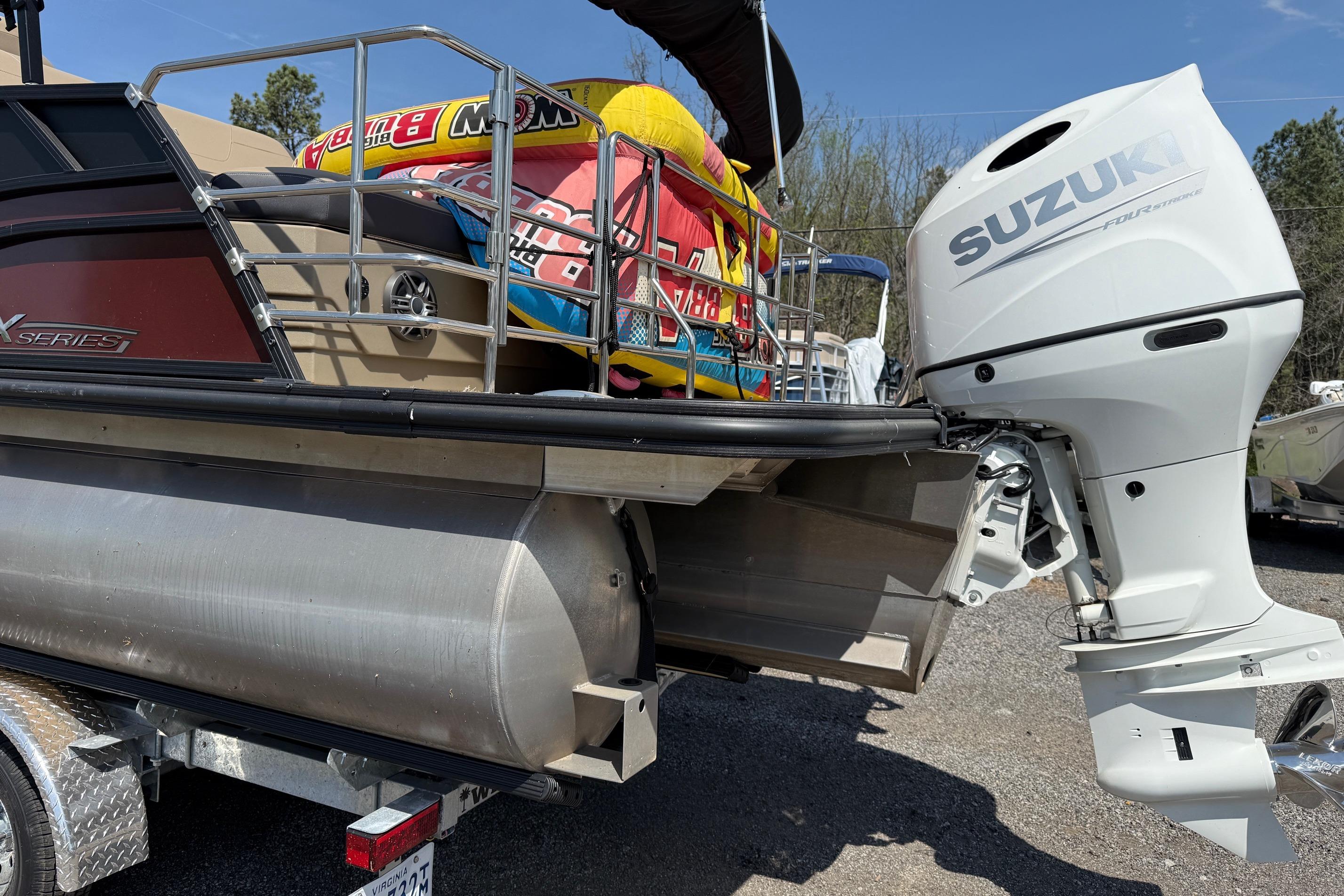2024 Sylvan X1 CLZ DH pontoon boat with Suzuki outboard motor and colorful inflatables.