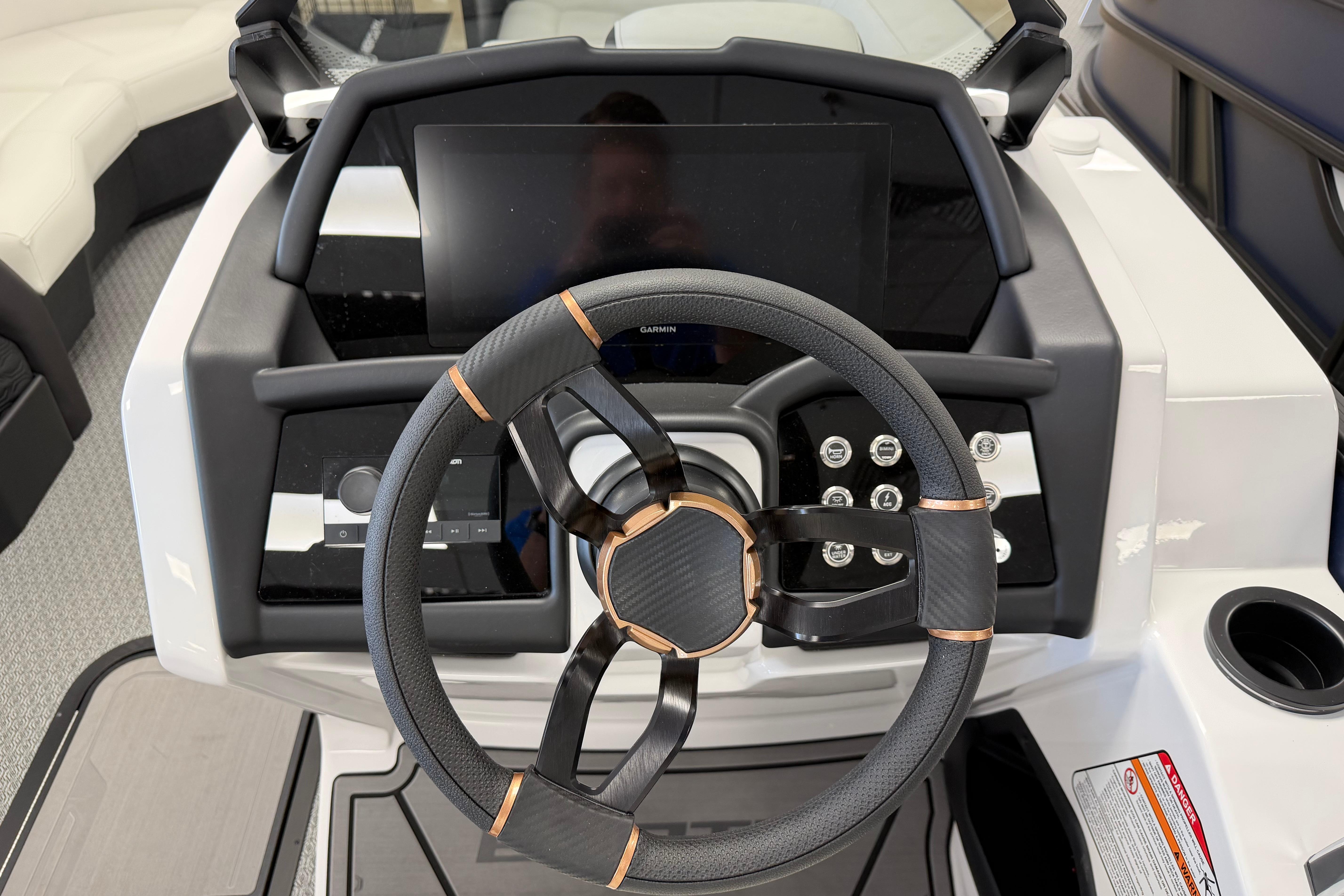 Steering wheel and dashboard of 2026 Evotti 721CS boat, featuring modern controls and display.