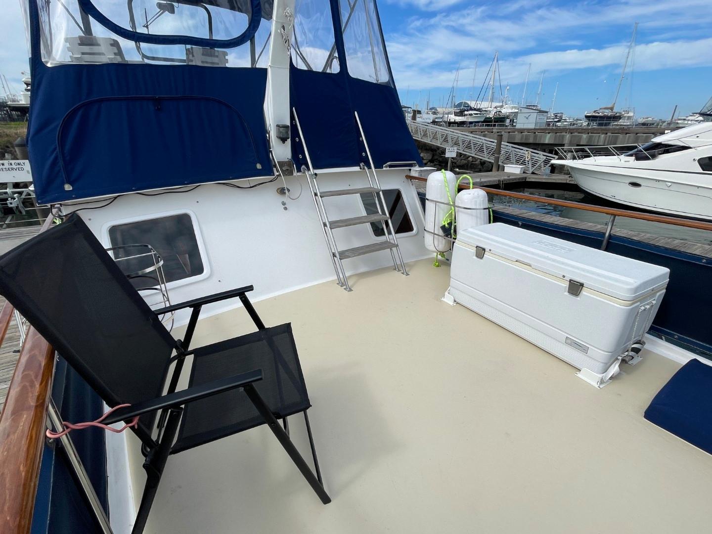 1983 Ocean Alexander TRI Cabin yacht deck with chairs and storage box.