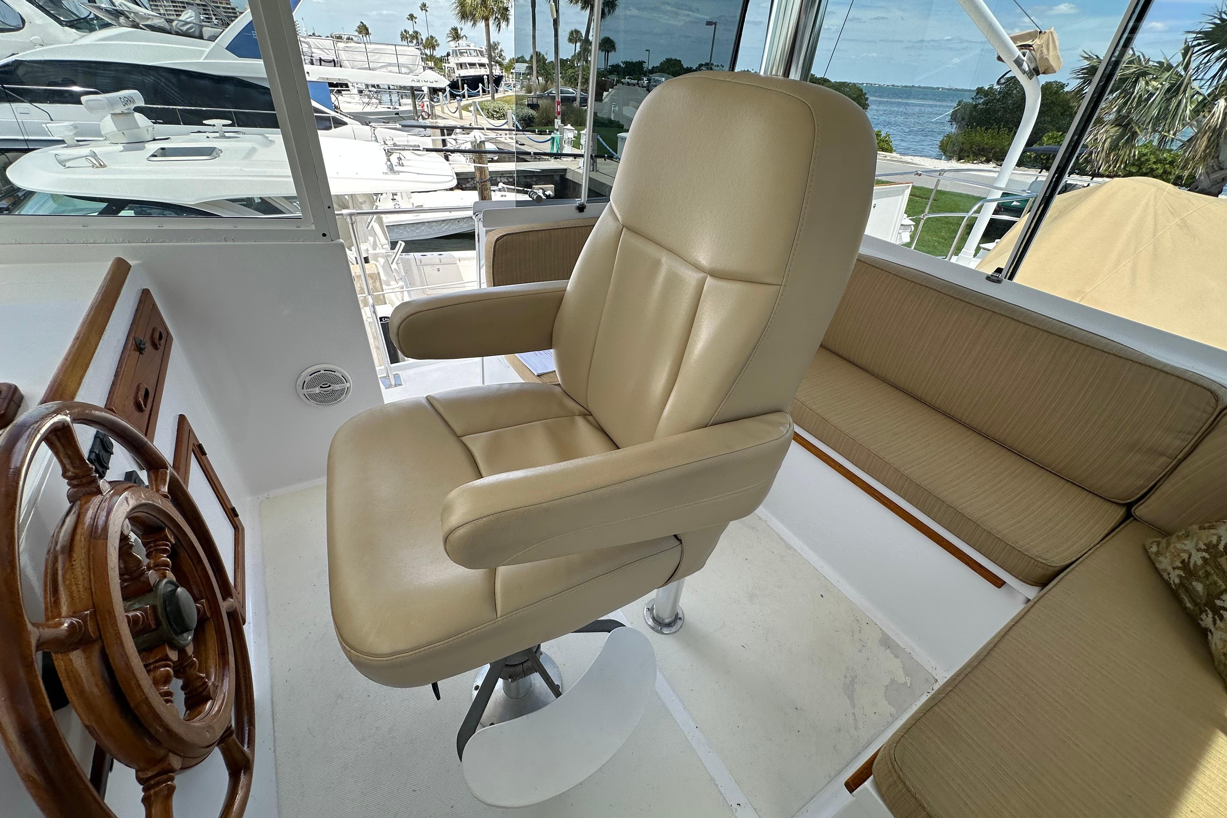 Captain's chair and helm on 1987 Kadey-Krogen Manatee 36 yacht, docked at marina.