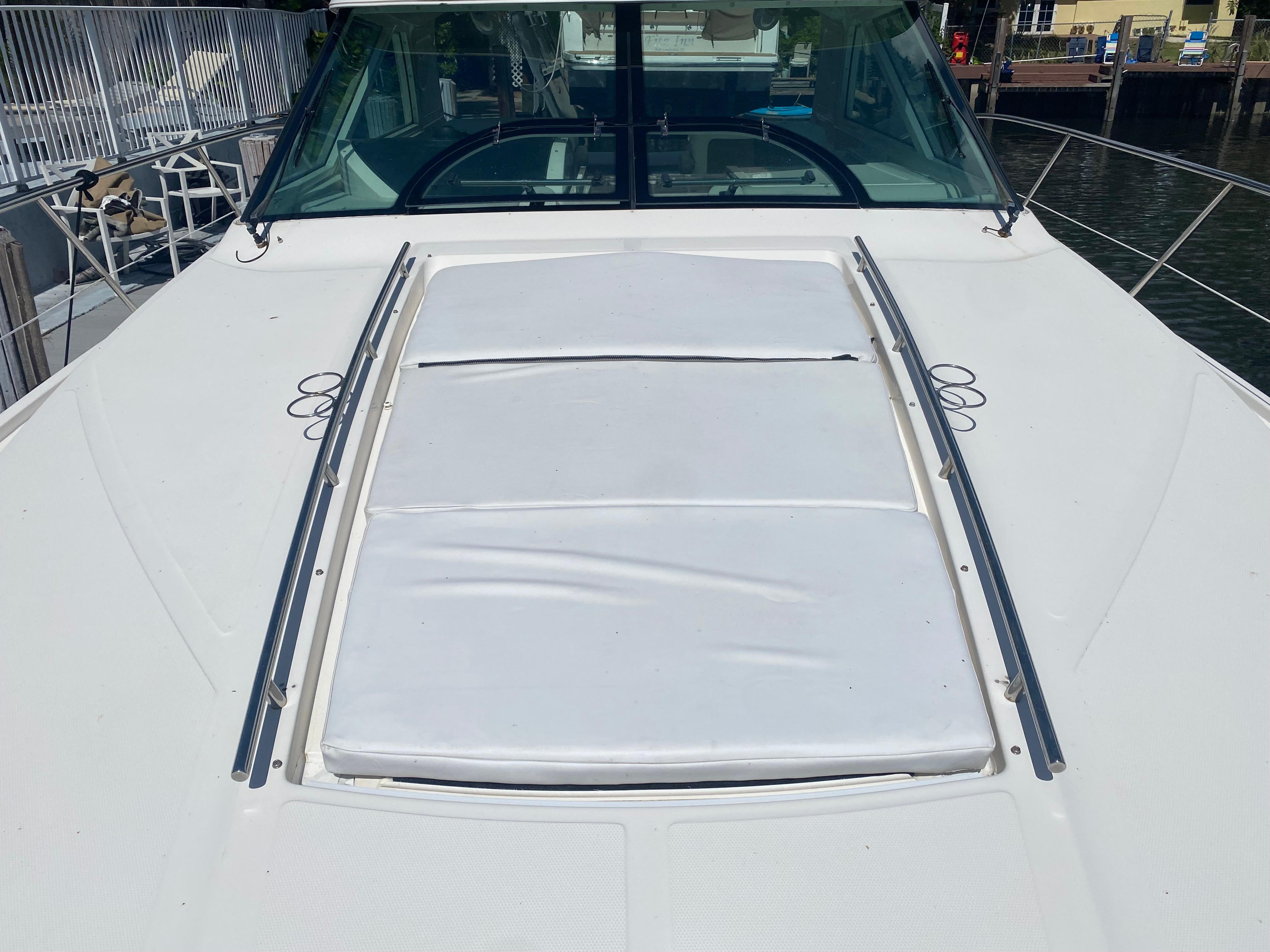 2012 Sea Ray 450 Sundancer yacht deck with sunpad, docked by the water.