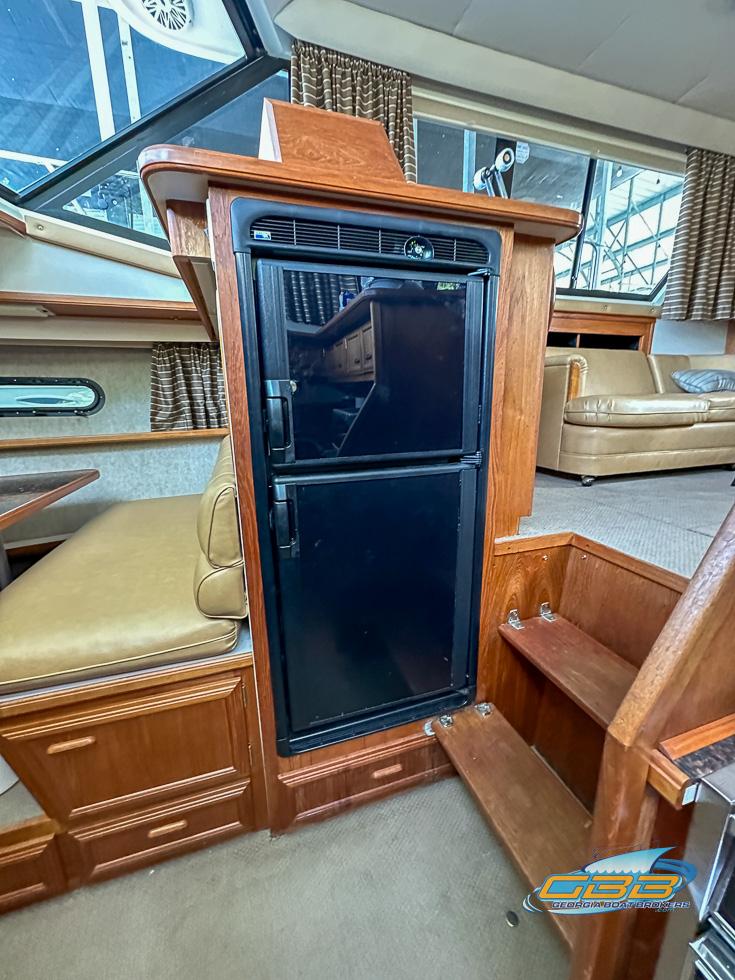 1989 Carver 3807 Aft Cabin interior with wood cabinetry and compact refrigerator.
