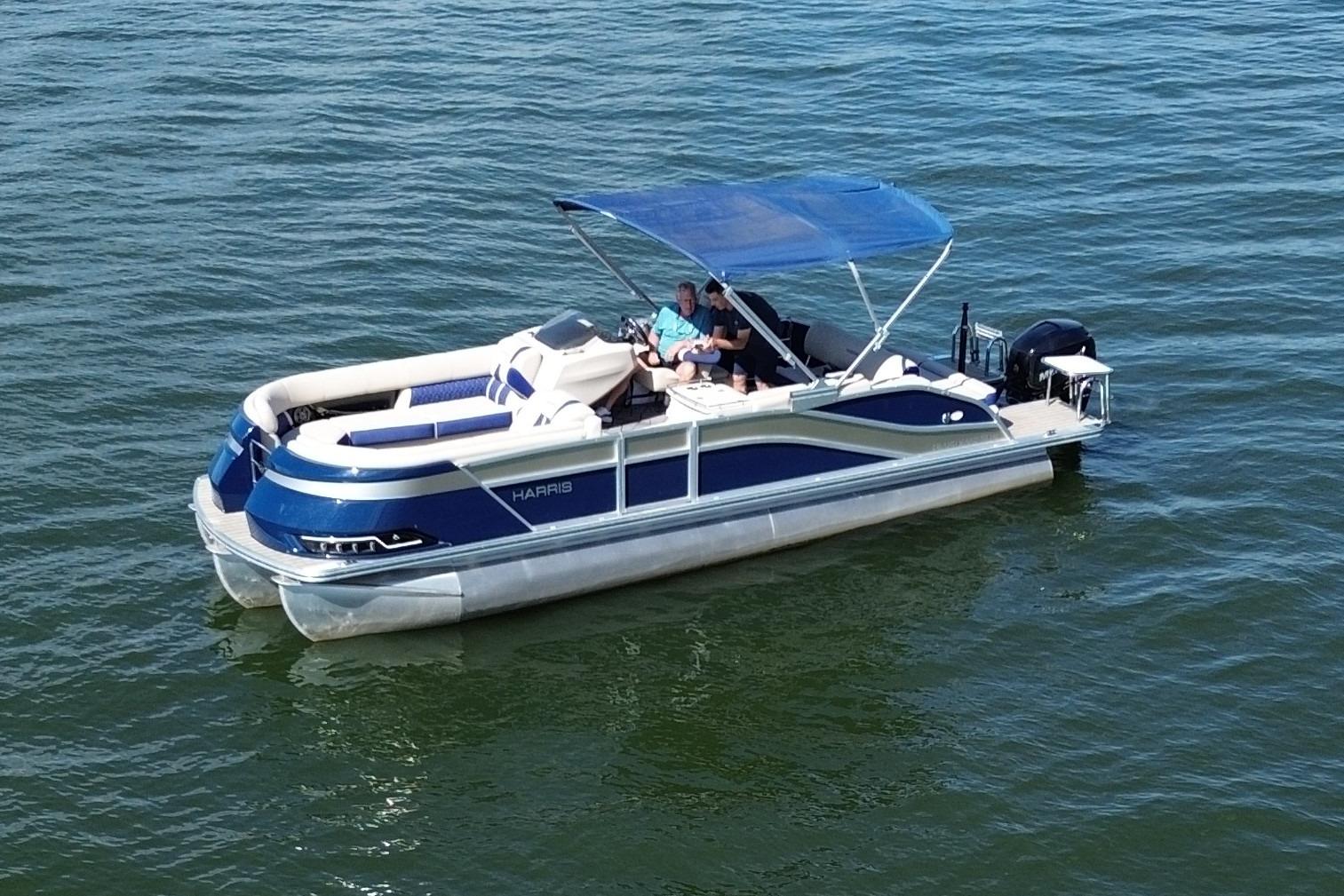 2022 Harris Grand Mariner 250 pontoon boat on water with blue canopy.