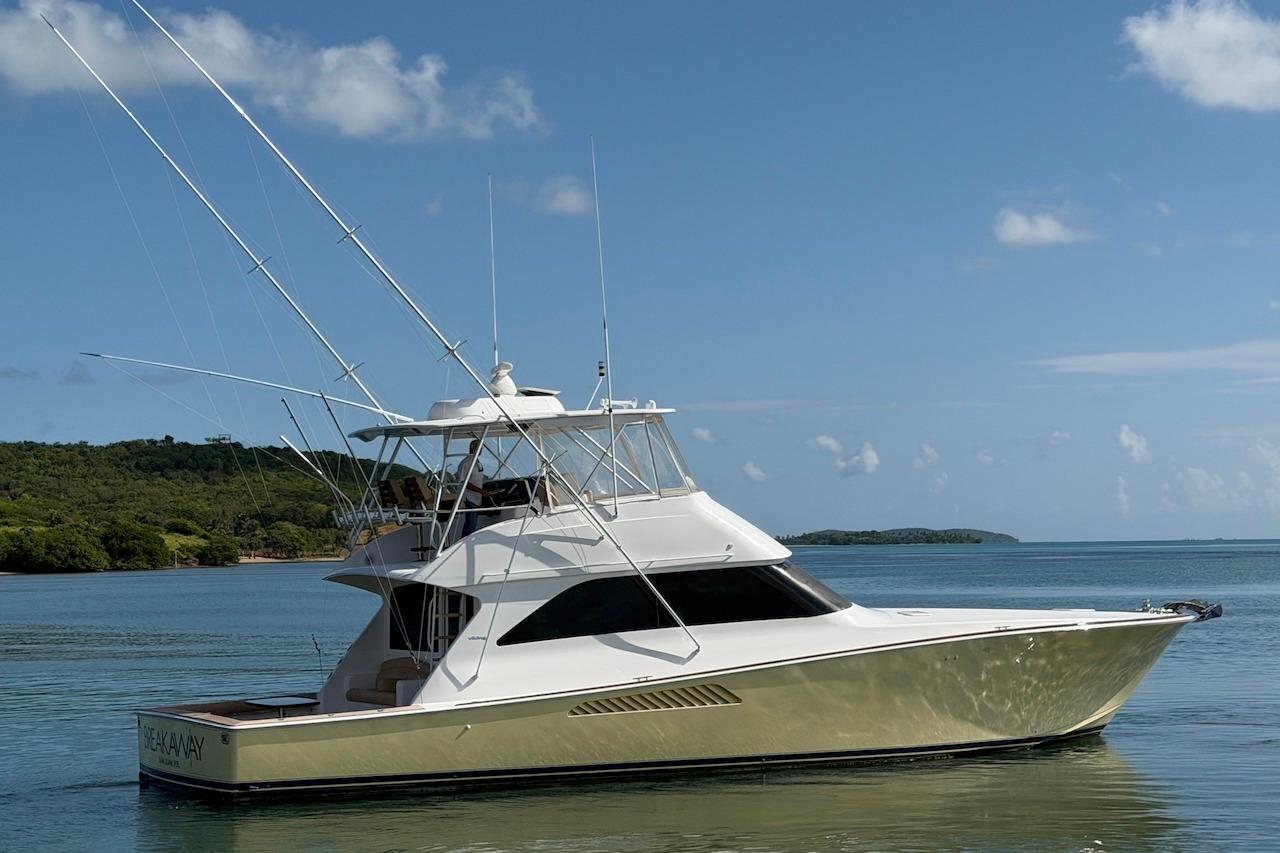 2004 Viking 56 Convertible yacht on calm waters under a clear blue sky.