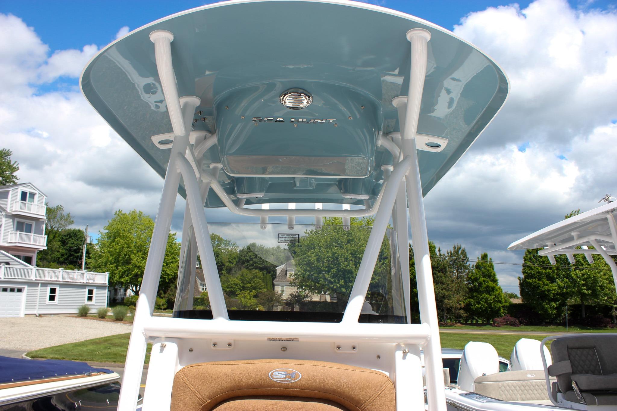 2027 Sea Hunt Ultra 234 boat with T-top, viewed from the helm, under a partly cloudy sky.