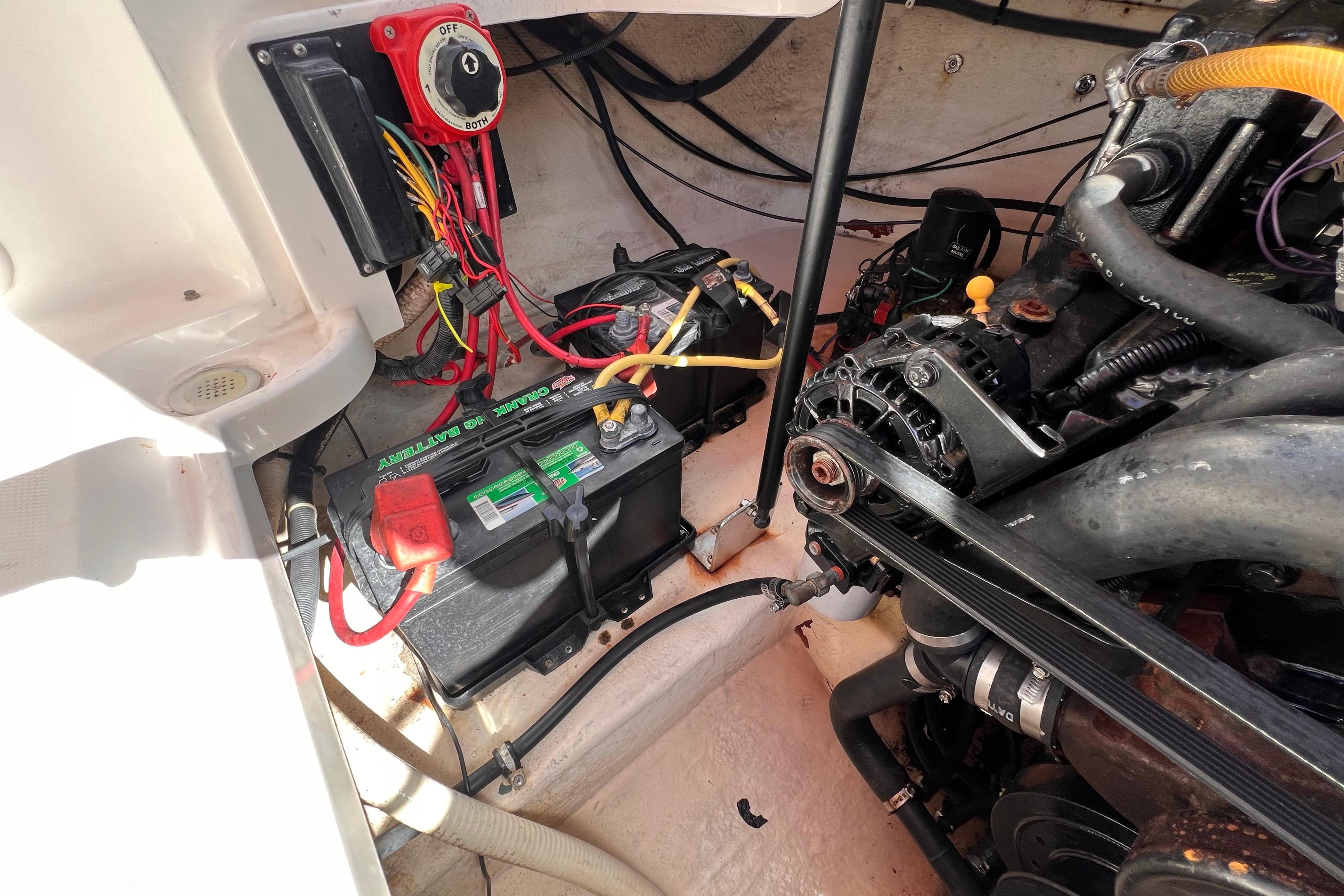 Engine compartment of a 2002 Chaparral 232 Sunesta with battery and wiring.