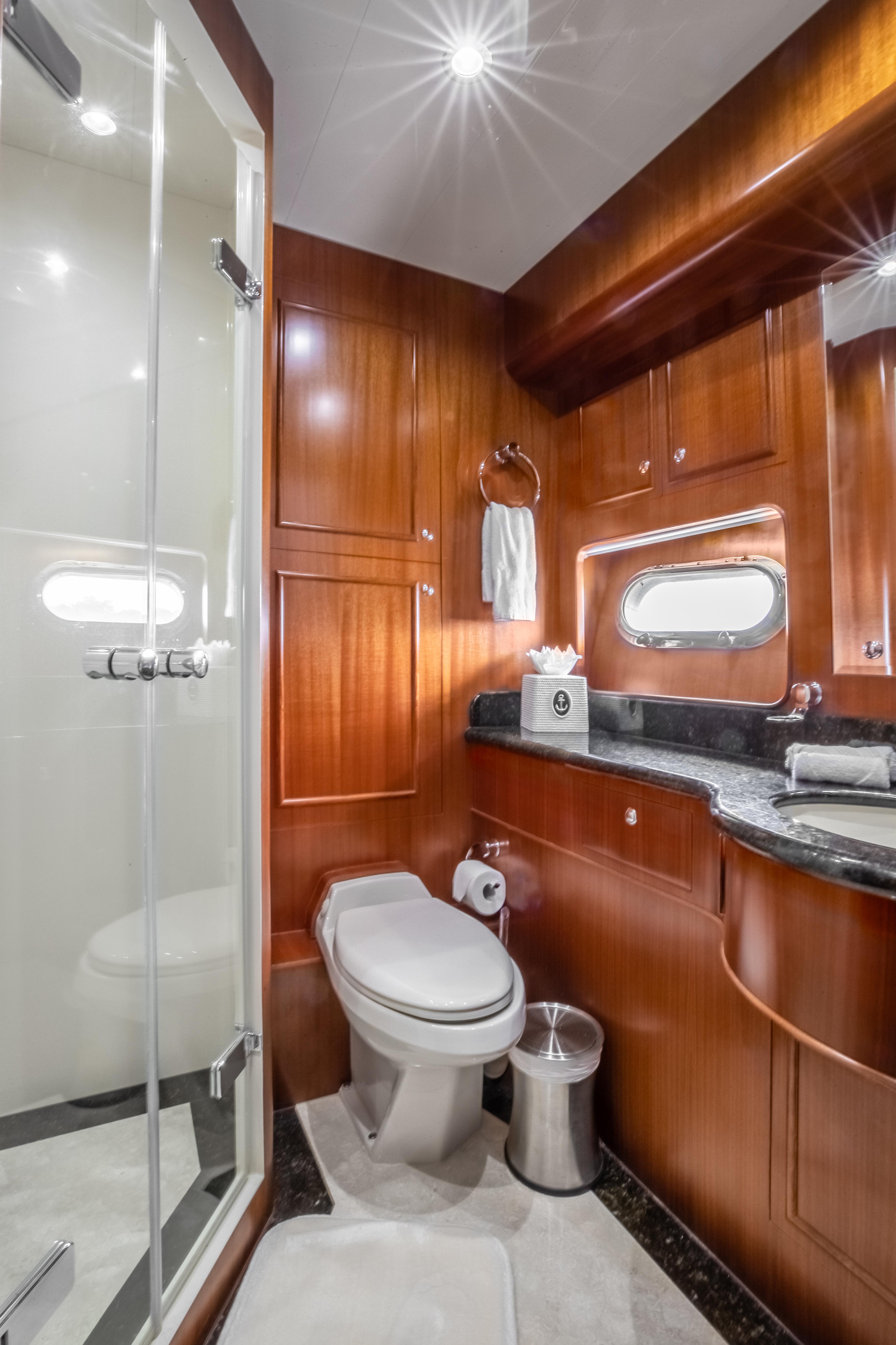 Luxurious bathroom on a 2005 Horizon 94 Motoryacht with wooden cabinetry and modern fixtures.