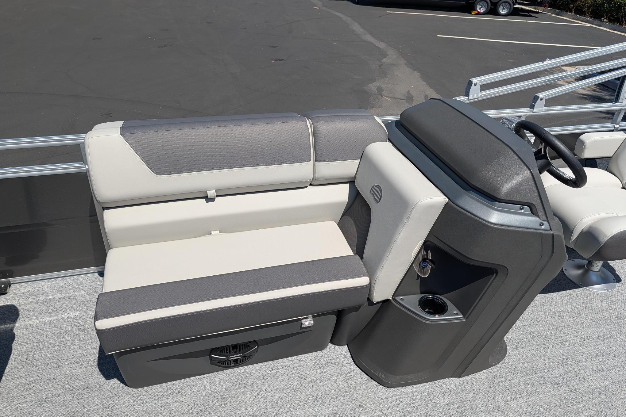2026 Sun Tracker Fishin' Barge 22 DLX interior with gray seating and steering console.