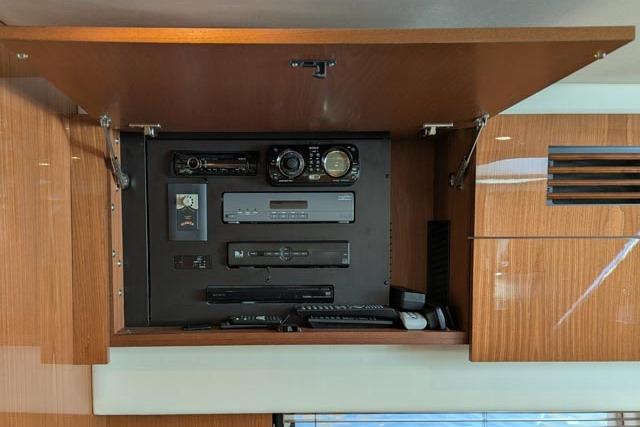 Control panel inside 2013 Sea Ray 470 Sundancer yacht, featuring various electronic devices.