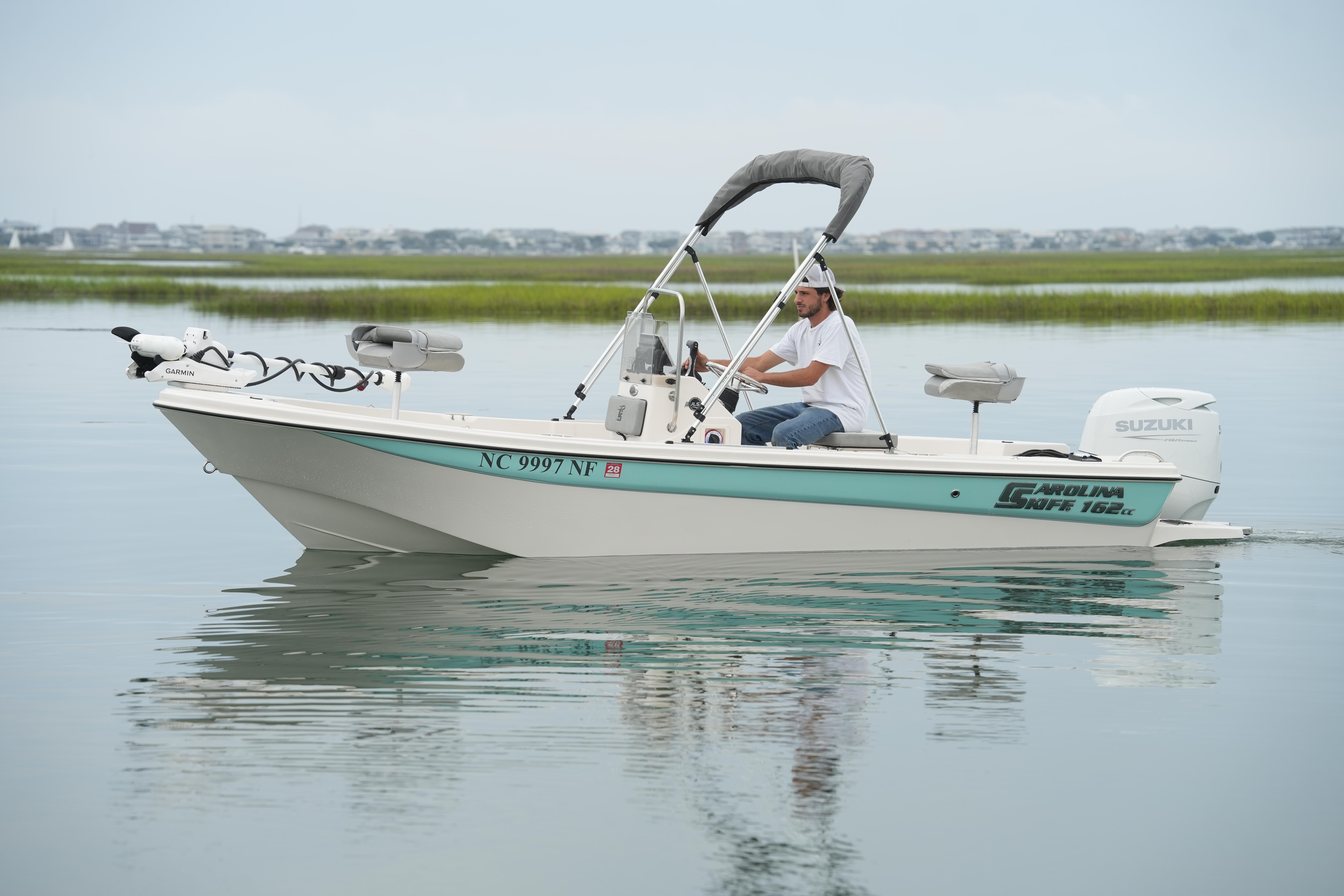 2025 Carolina Skiff 162 JLS boat cruising on calm water with a Suzuki outboard motor.