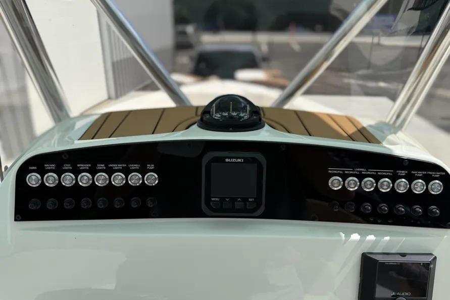 2026 Pioneer 220 Bay Sport boat dashboard with Suzuki controls and various switches.