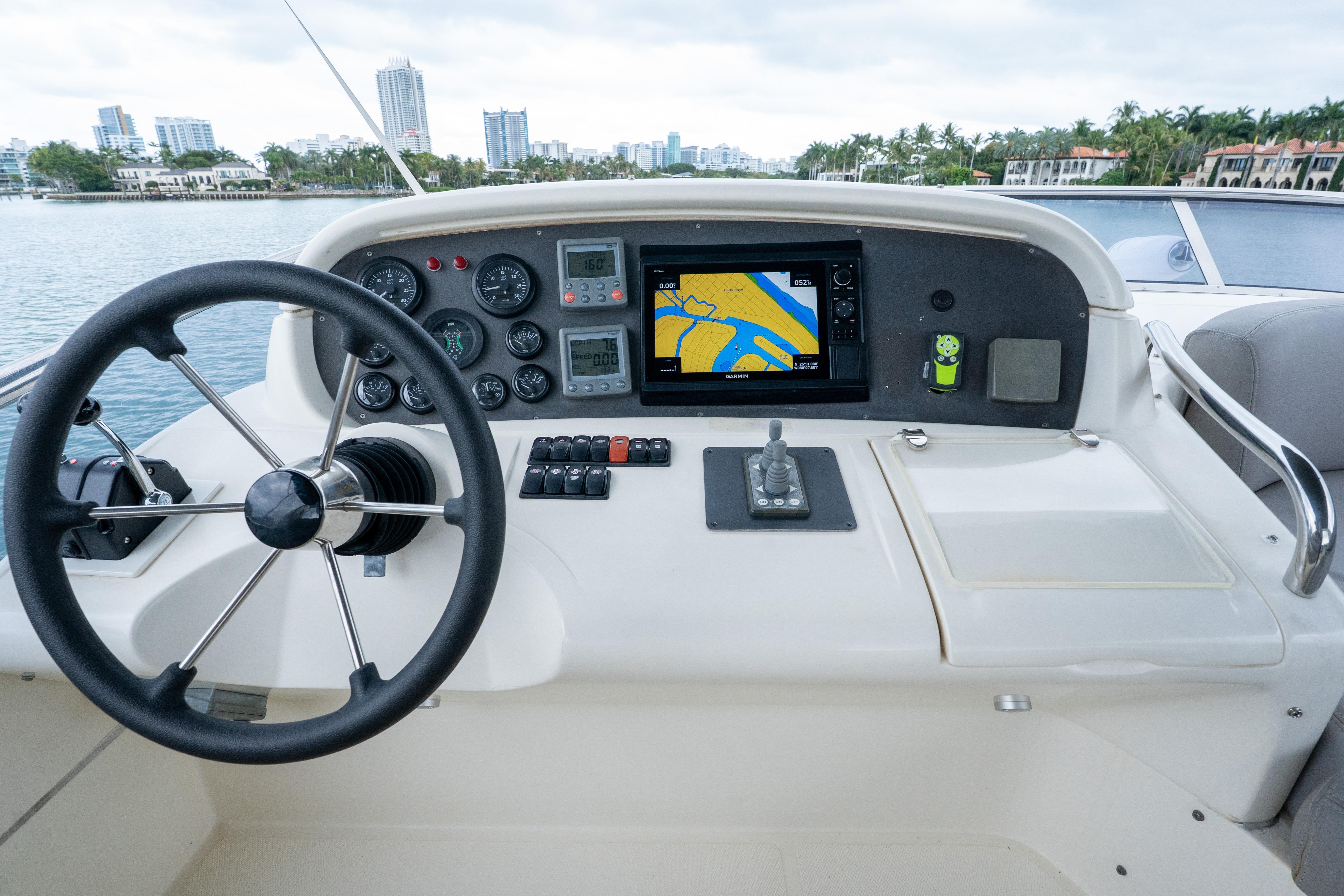 Helm of 2008 Azimut 62E yacht with navigation controls and city skyline view.
