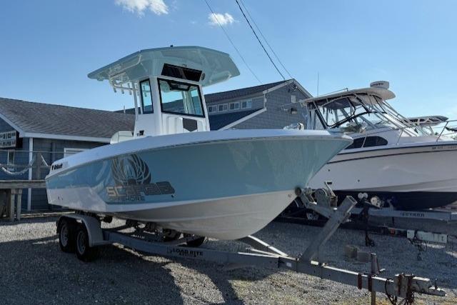 2025 Wellcraft 223 Fisherman boat on trailer, parked outdoors under clear sky.