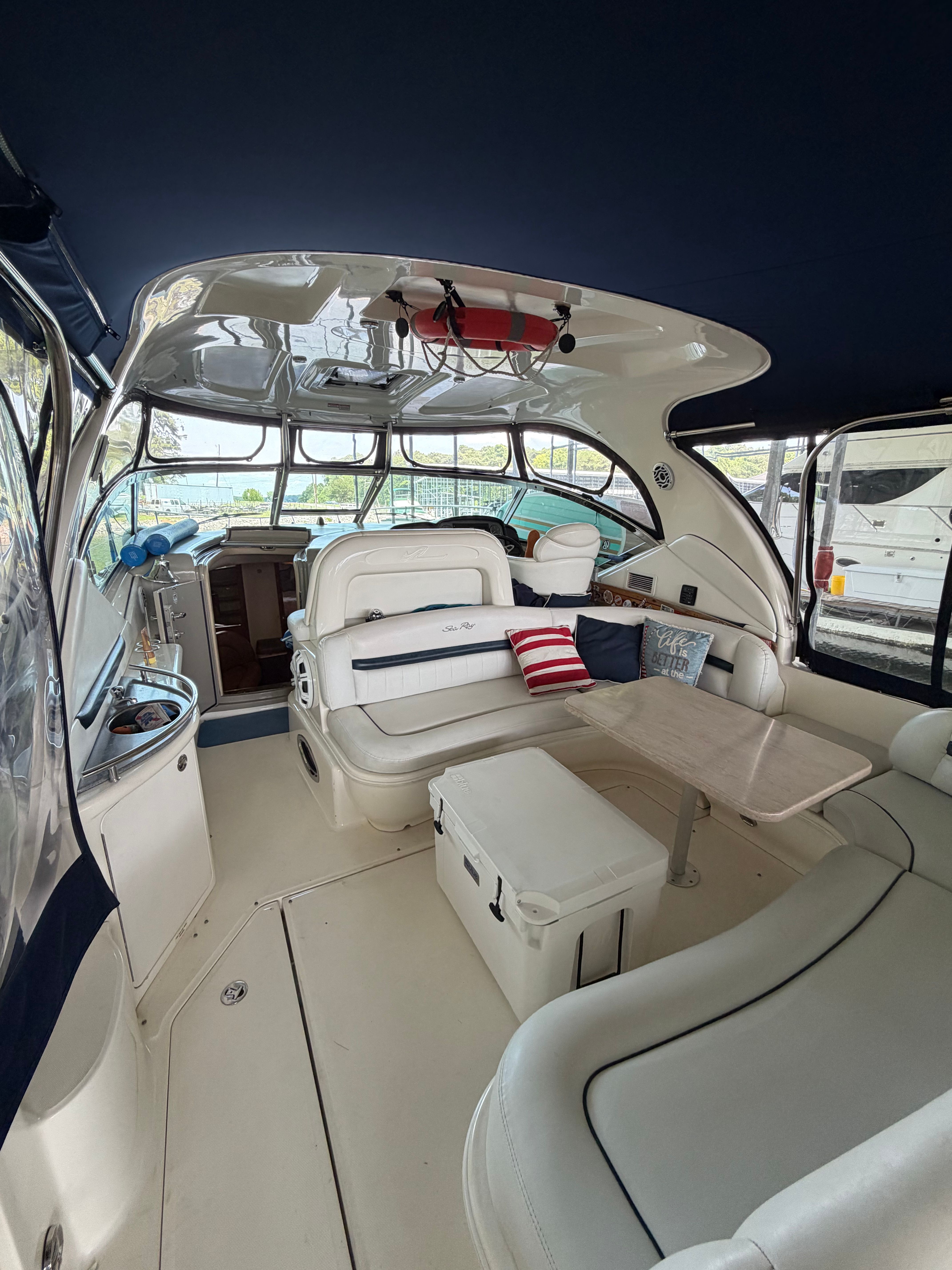 Interior of a 2005 Sea Ray 420DA with white seating and table.