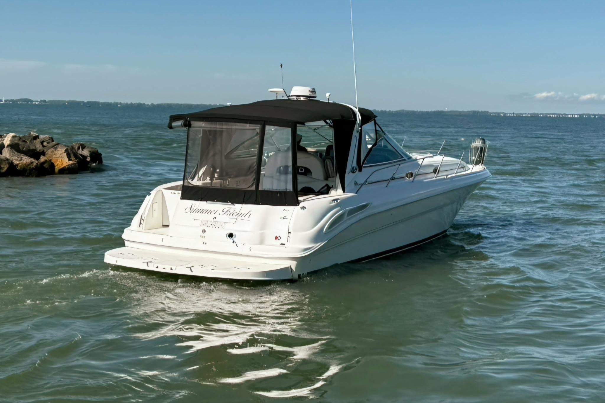 2002 Sea Ray 410 Sundancer yacht cruising on open water under clear skies.