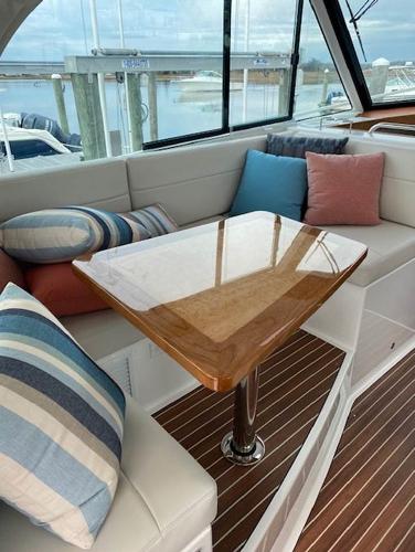 Luxurious seating area on the 2025 Back Cove 39O yacht with a polished wooden table.