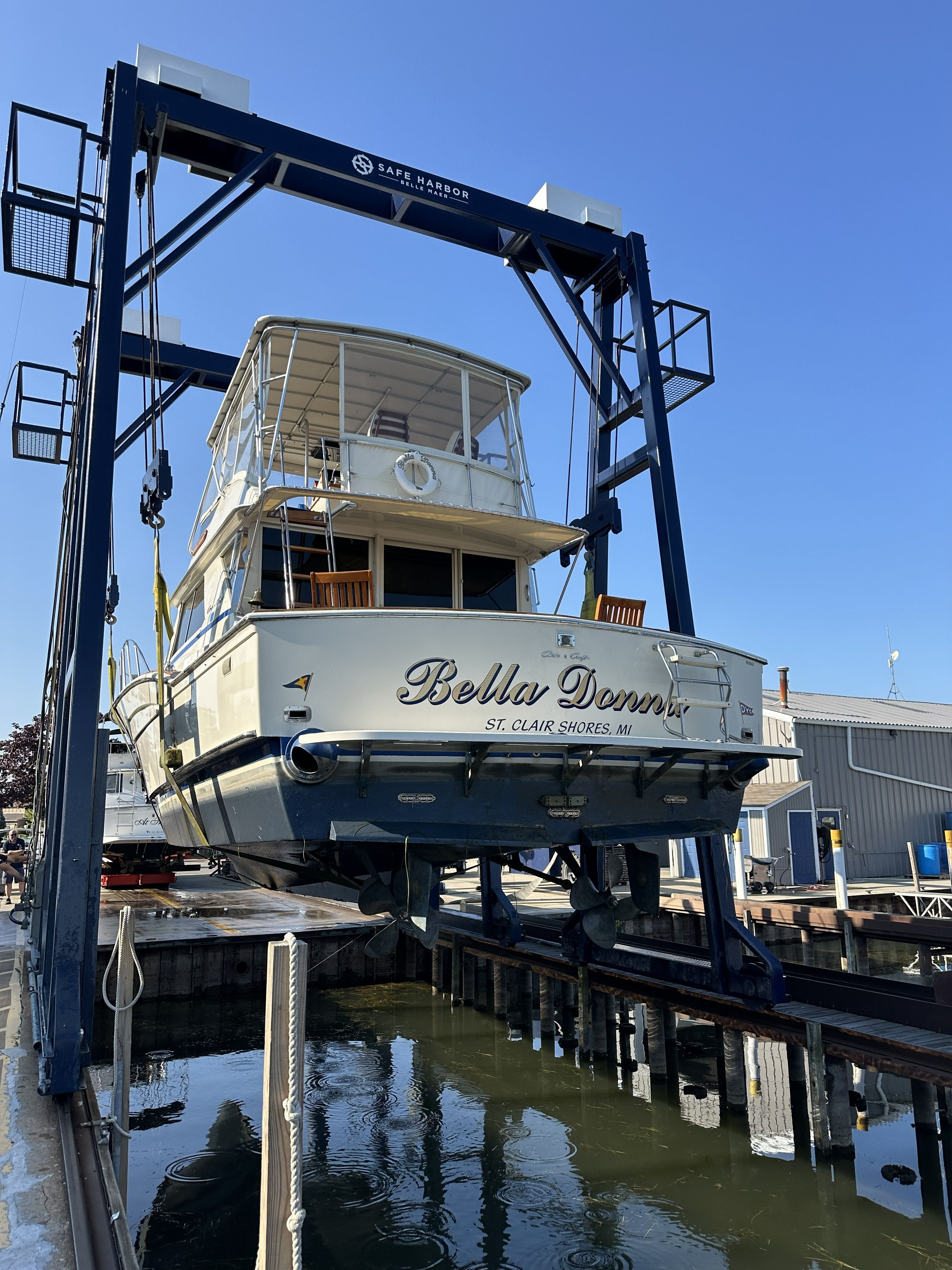A 1979 Chris-Craft 45 TF boat being lifted out of the water by a crane.