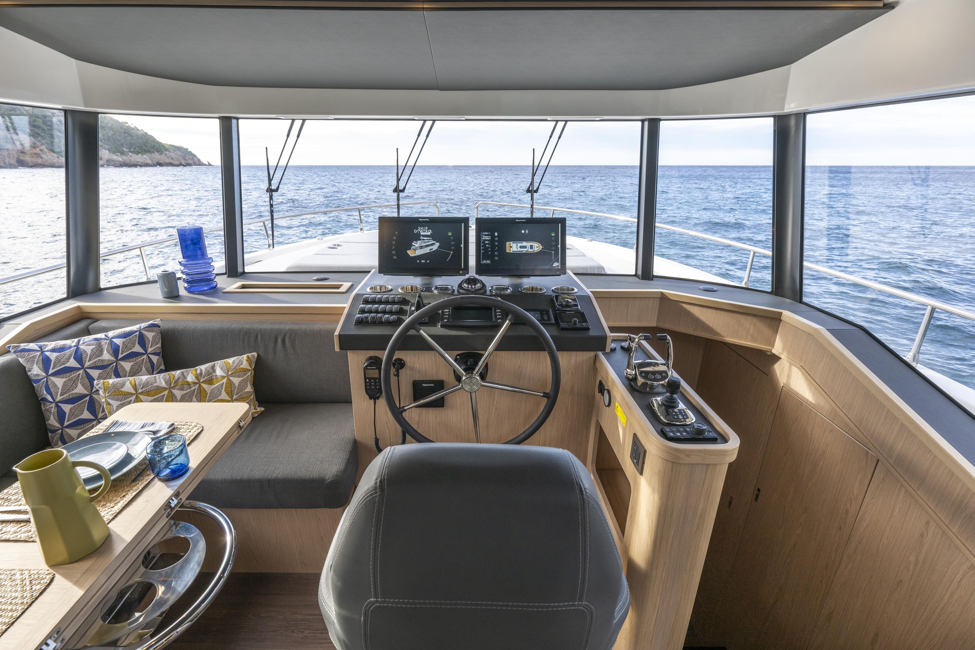 Interior of 2026 Beneteau Swift Trawler 54, featuring helm, seating, and ocean view.