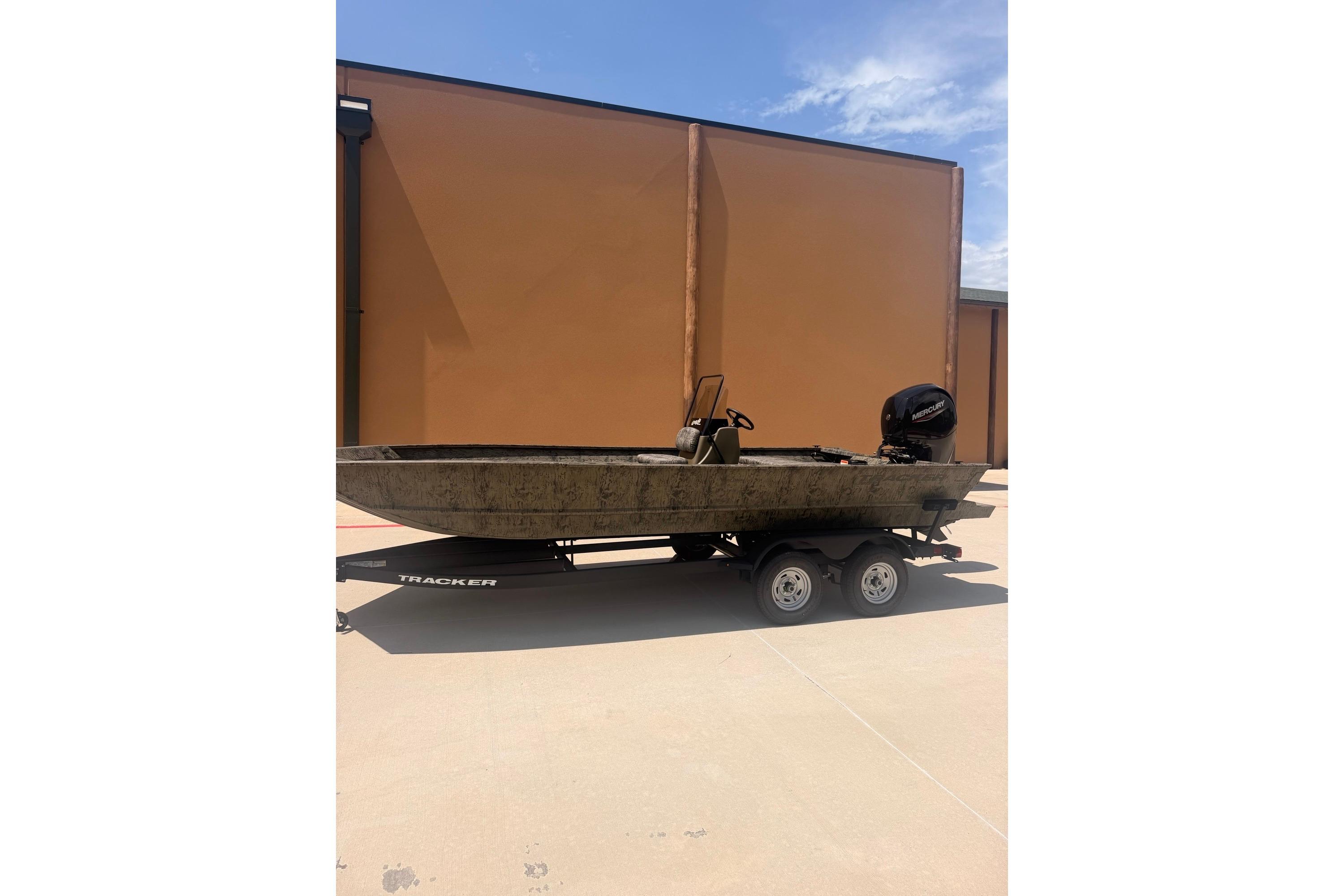 2026 Tracker Grizzly 2072 CC boat on trailer, parked outdoors under clear sky.