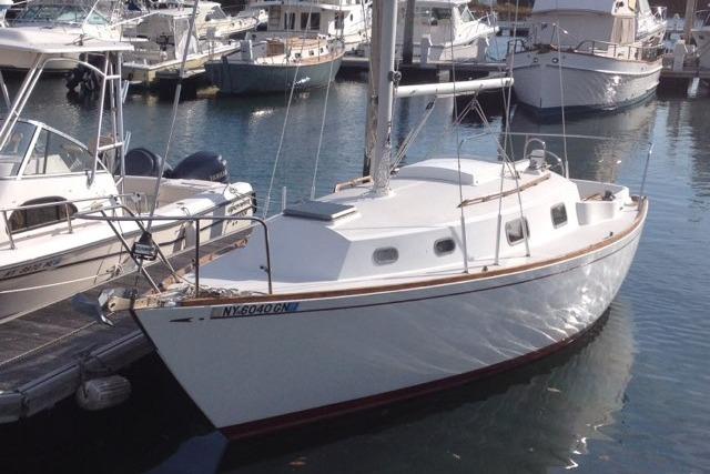 1980 Sloop 27.7 Bristol sailboat docked in a marina, surrounded by other boats.
