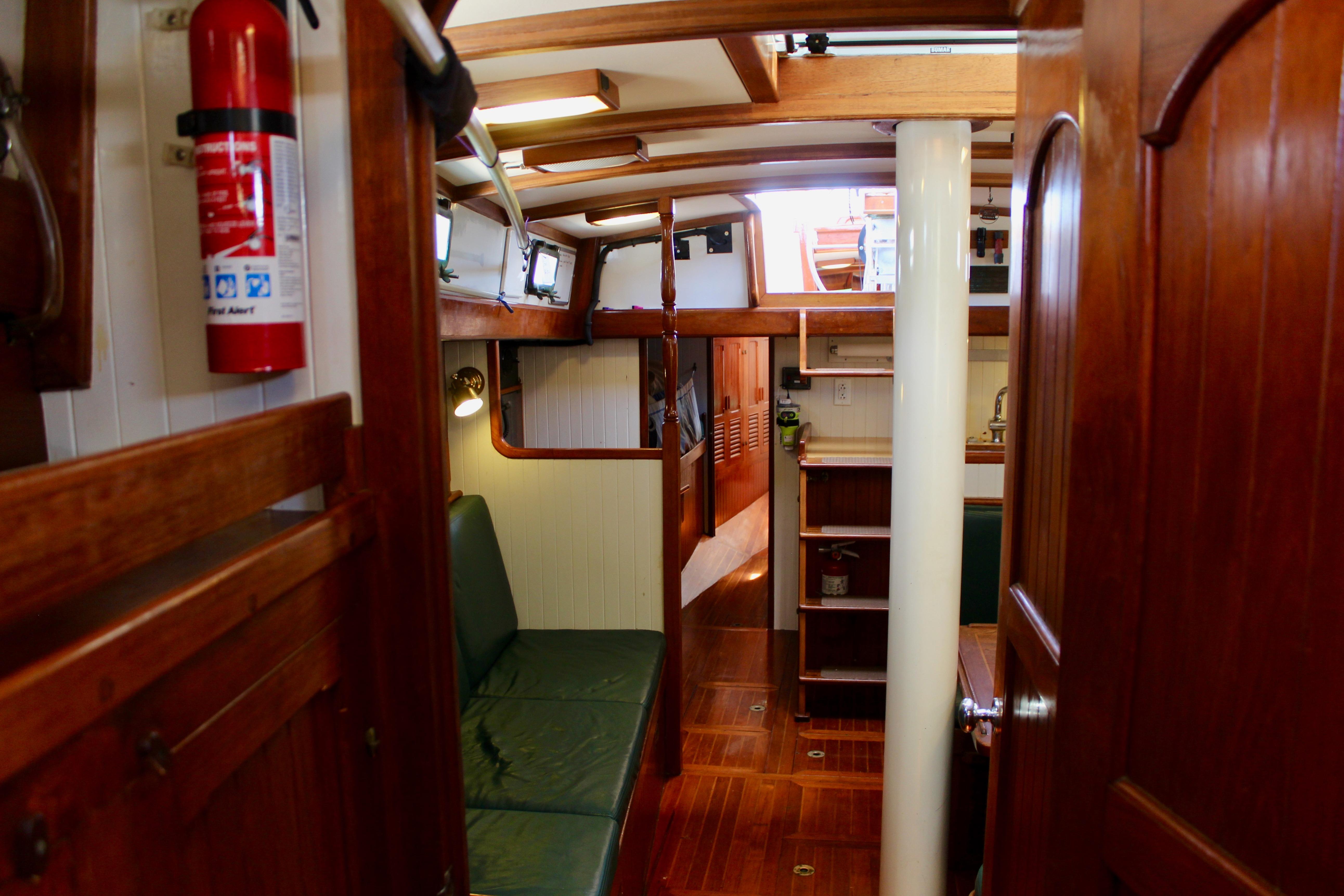 Interior of 1981 Kelly Peterson 46 sailboat with wooden finishes and cozy seating area.