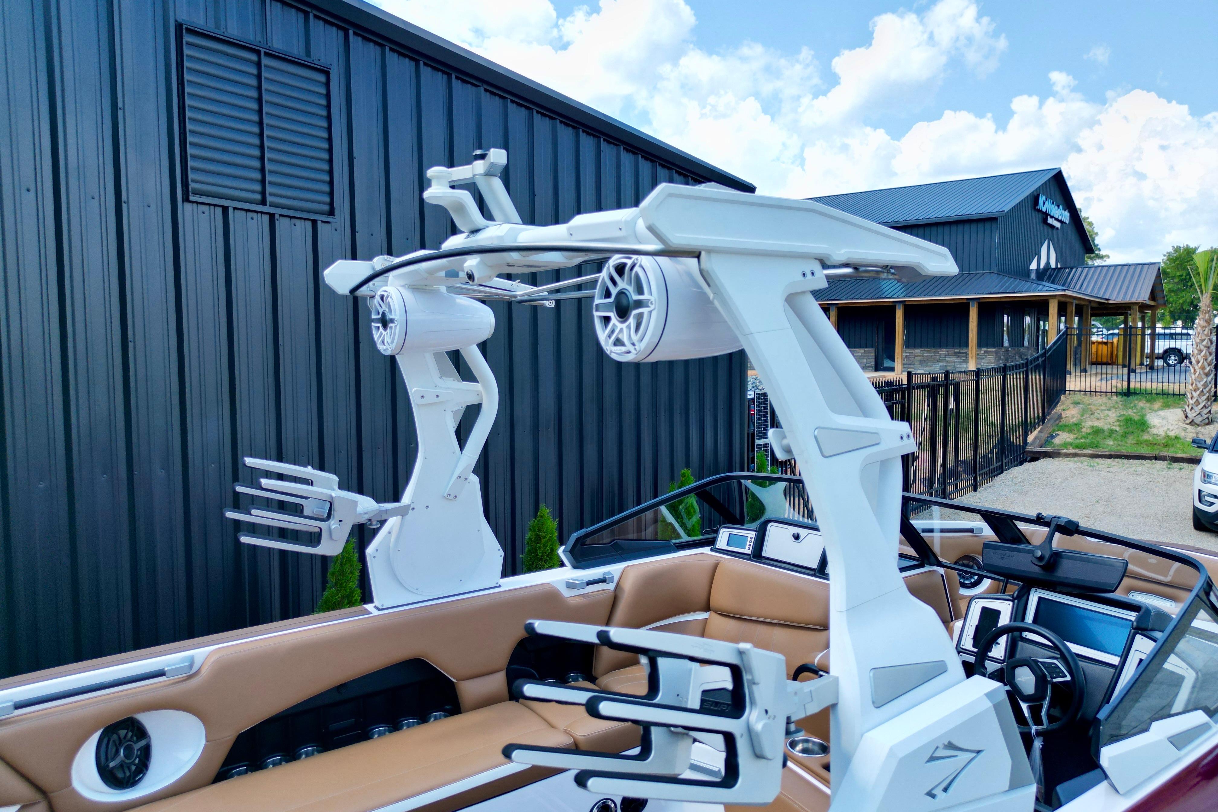 2021 Supra SE boat with advanced audio system and sleek design near a modern building.
