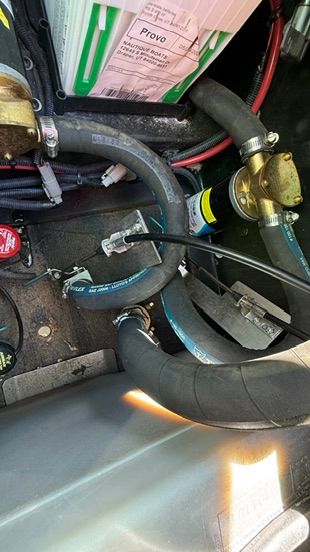 Close-up of hoses and cables in a boat's engine compartment.